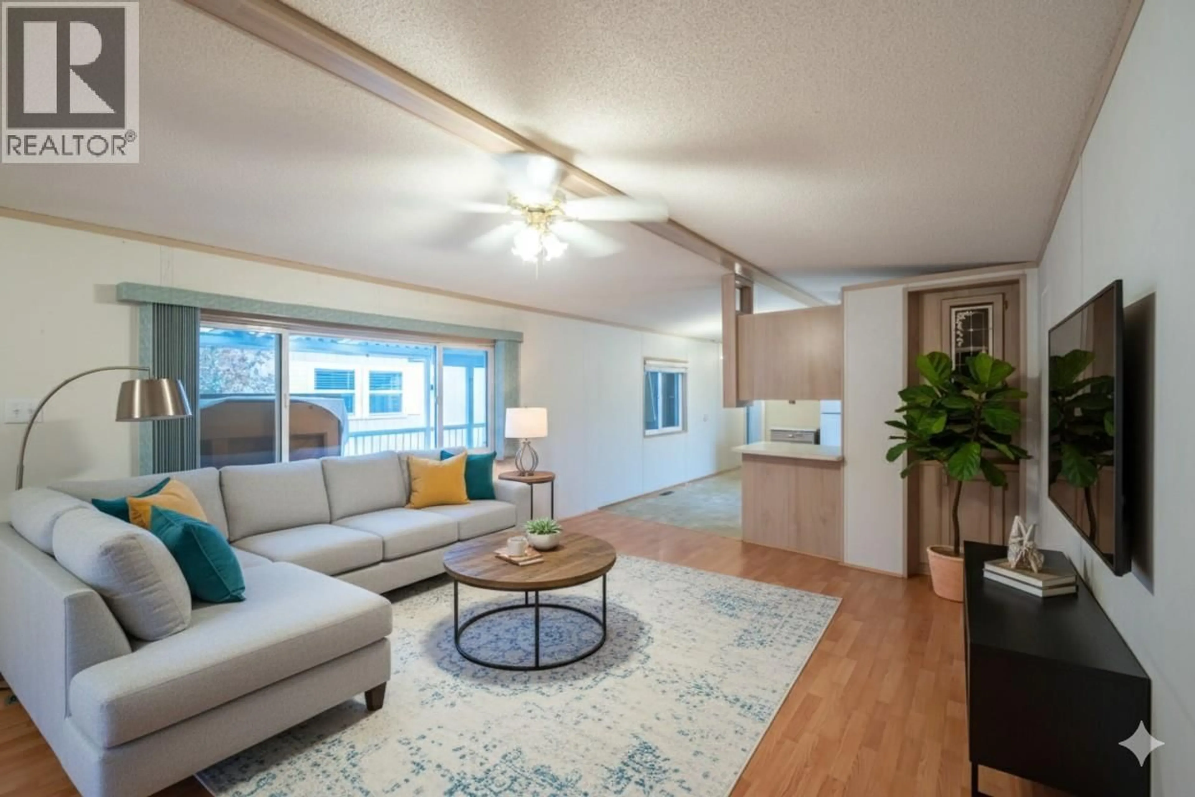 Living room with furniture, wood/laminate floor for 39 - 6778 TUCELNUIT DRIVE, Oliver British Columbia V0H1T0