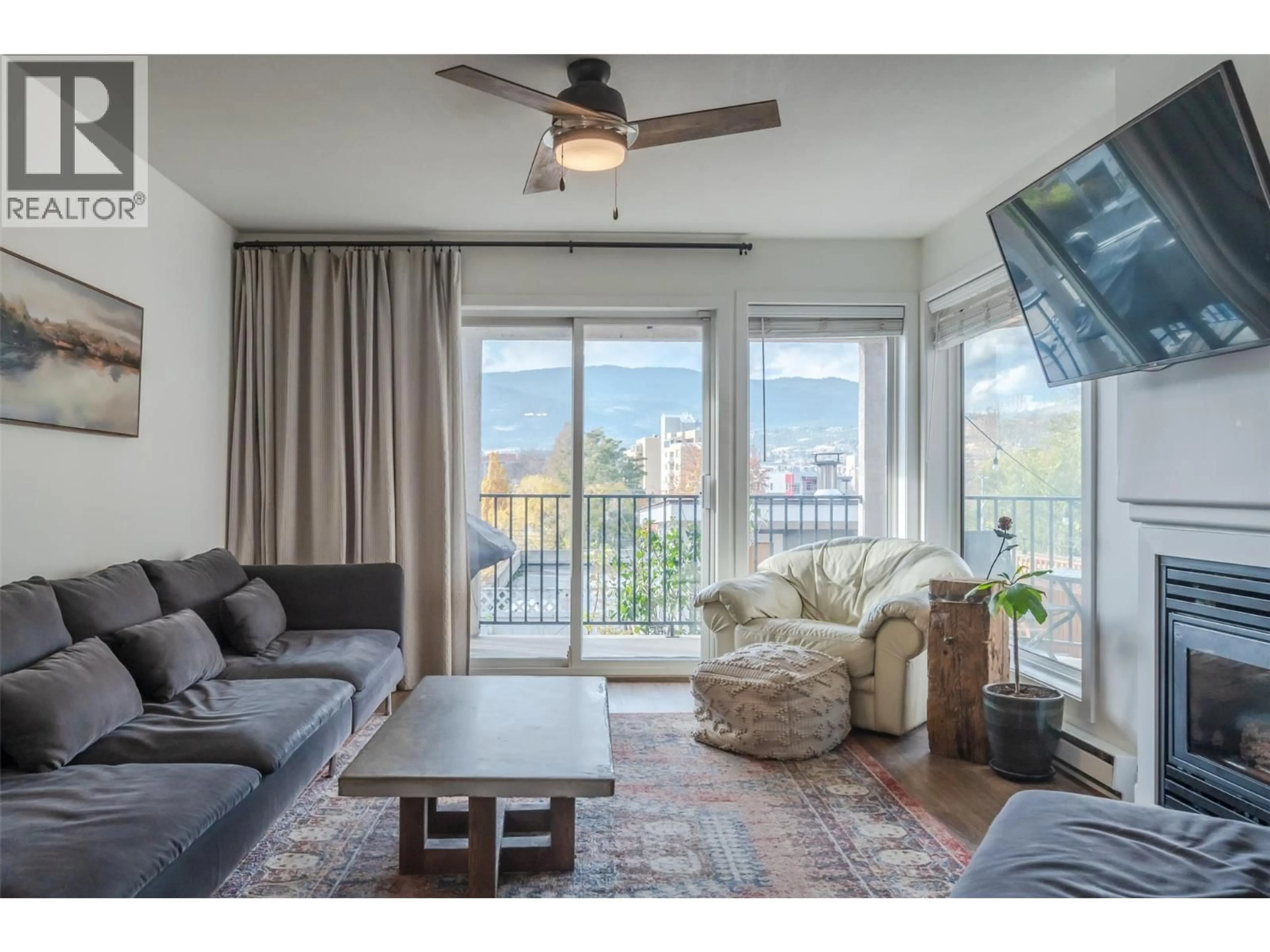 Living room with furniture, wood/laminate floor for 101 - 93 VAN HORNE STREET, Penticton British Columbia V2A4J9