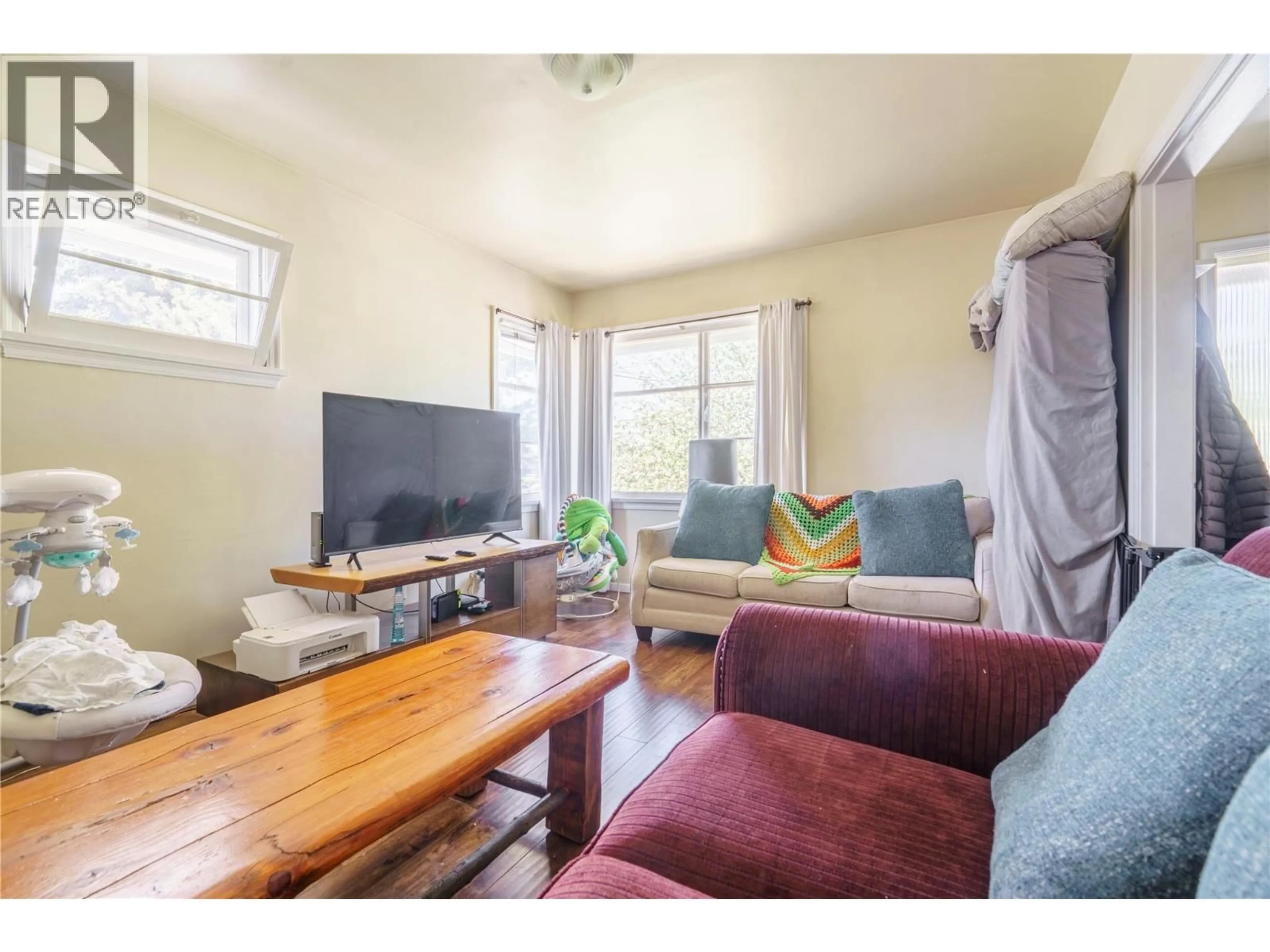 Living room with furniture, wood/laminate floor for 3095 GORDON DRIVE, Kelowna British Columbia V1W3R1