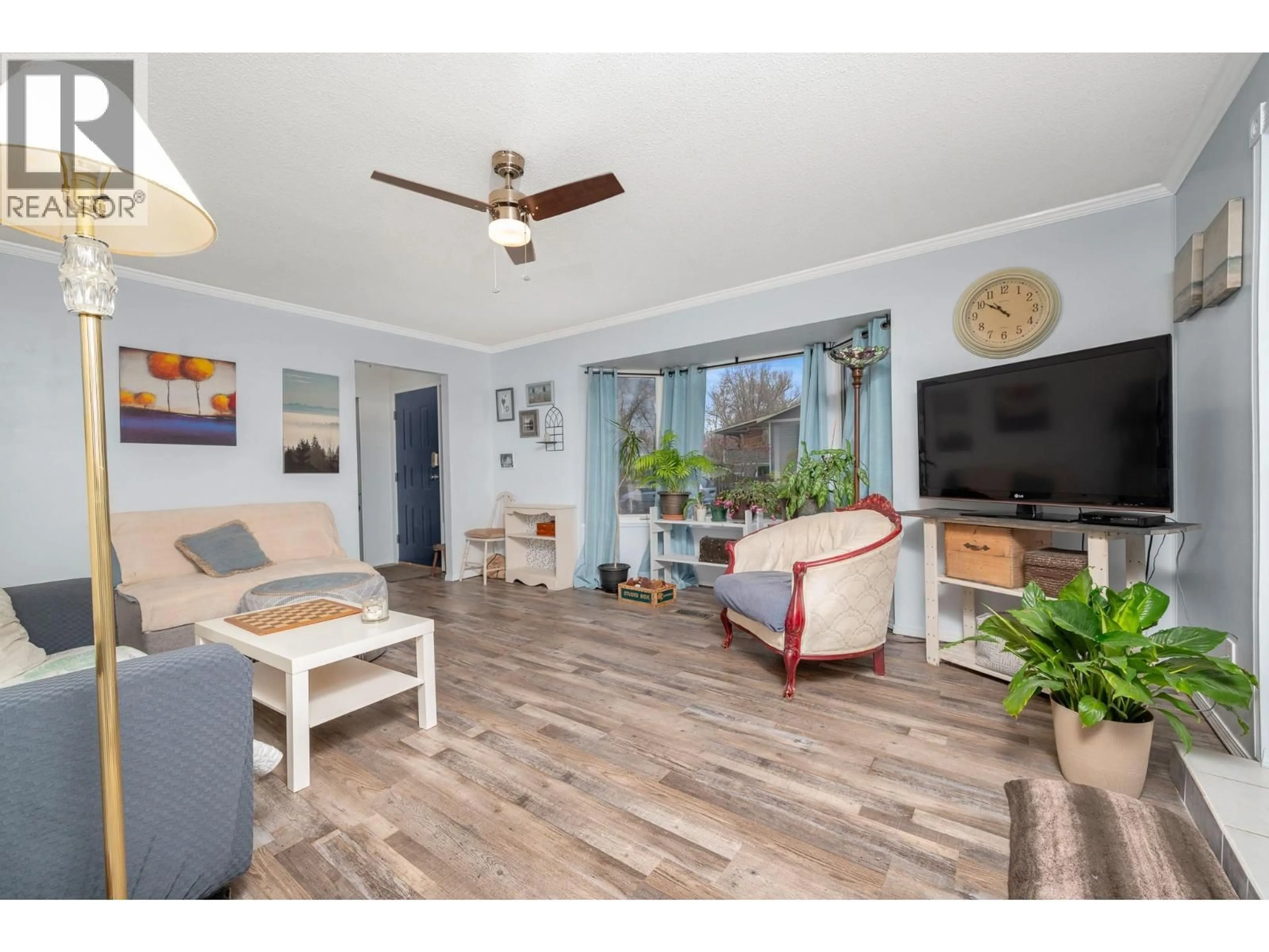 Living room with furniture, wood/laminate floor for 5513 WILLOW DRIVE, Vernon British Columbia V1T7W3