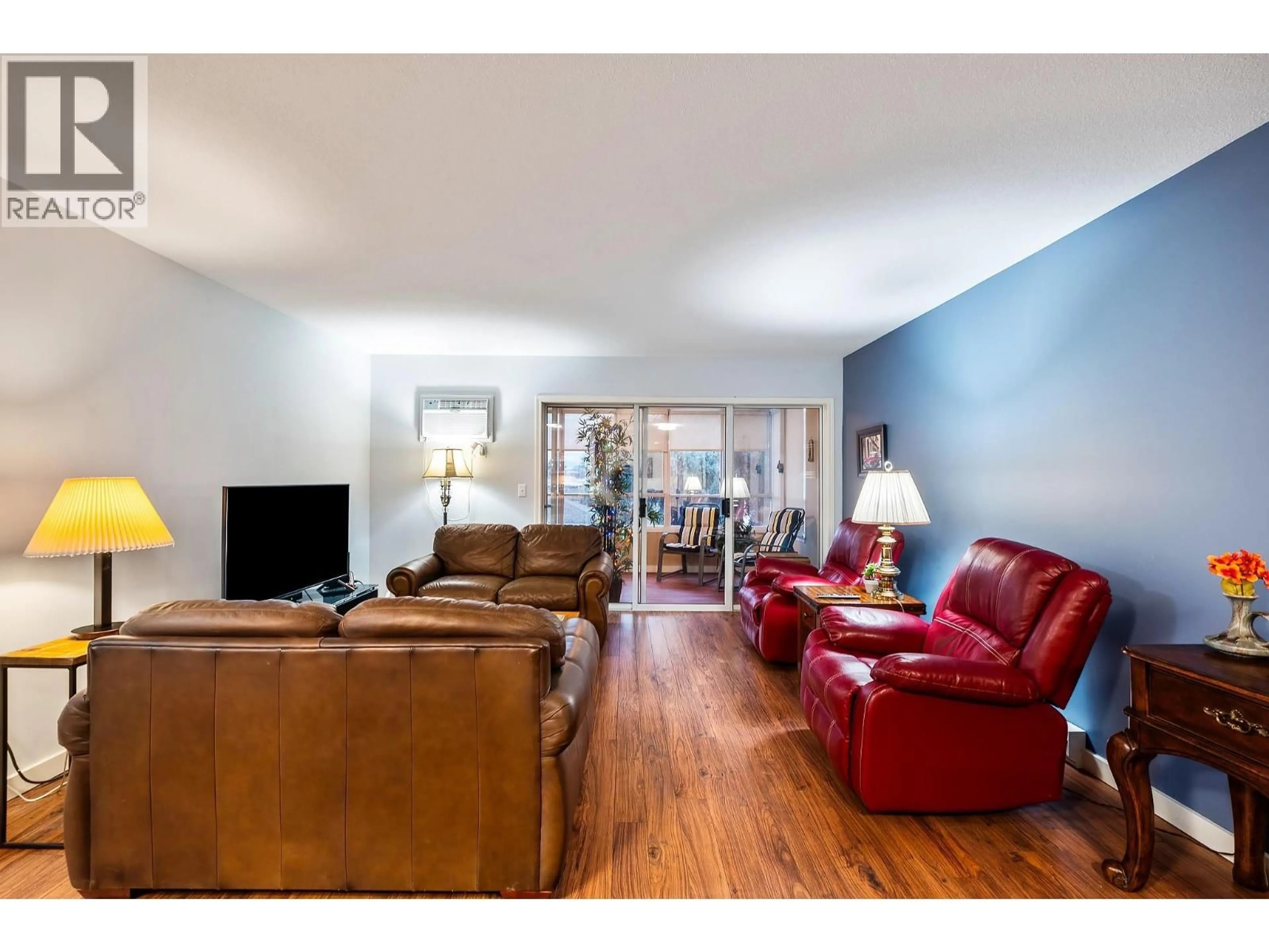 Living room with furniture, wood/laminate floor for 206 - 1055 LAWRENCE AVENUE, Kelowna British Columbia V1Y6M3