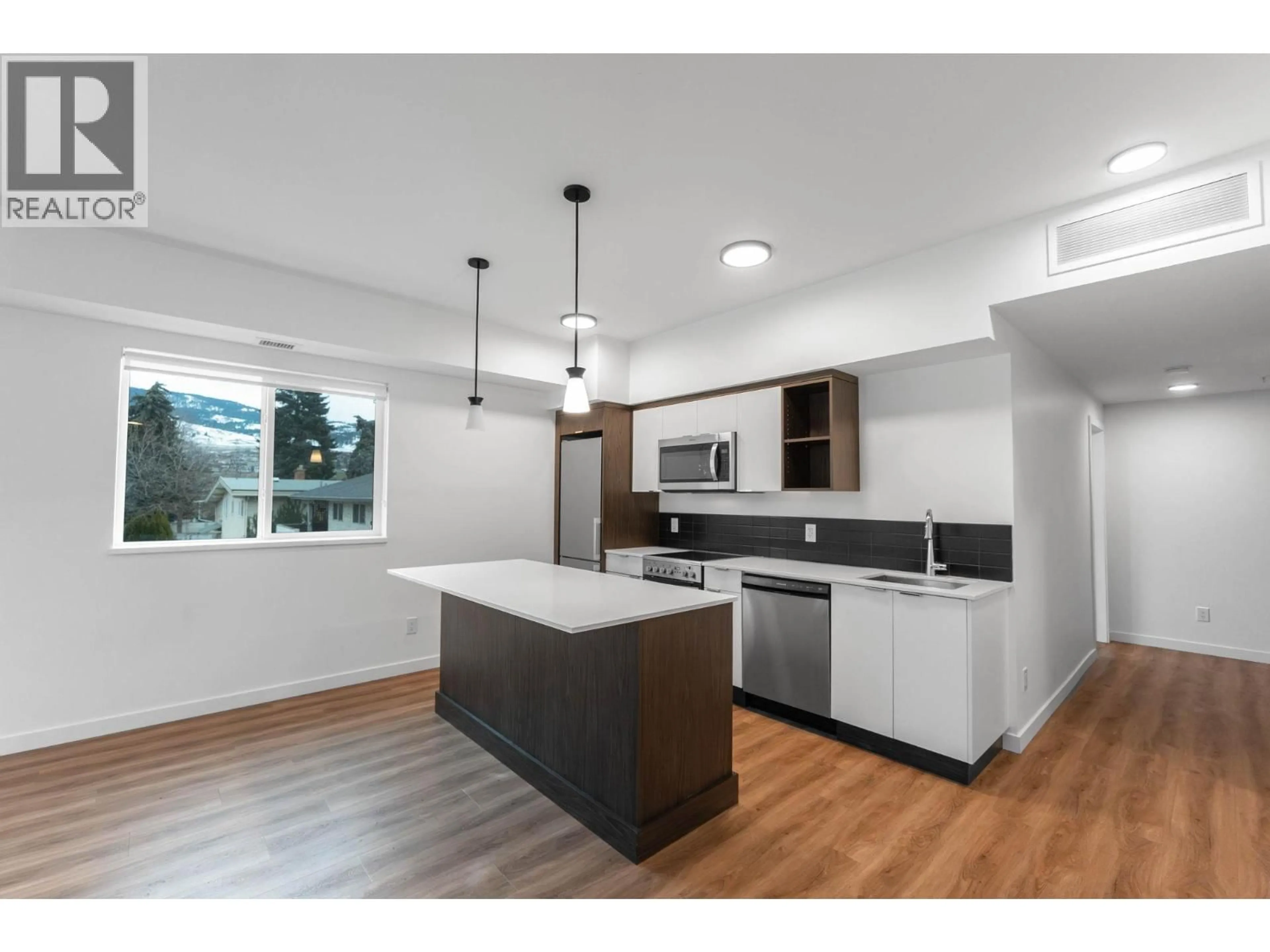Open concept kitchen, wood/laminate floor for 203 - 615 RUTLAND ROAD, Kelowna British Columbia V1X0B3