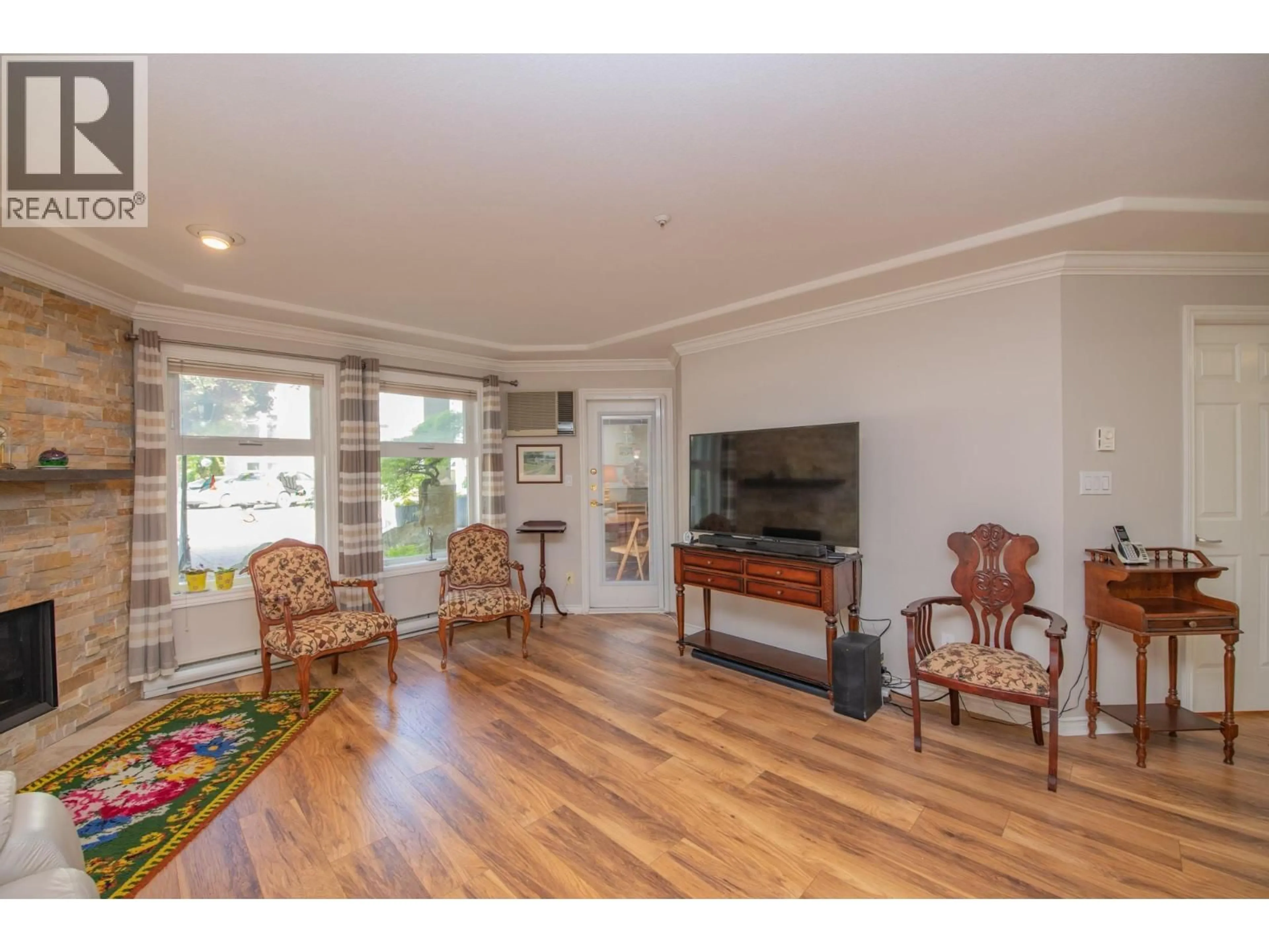 Living room with furniture, wood/laminate floor for 102 - 3300 CENTENNIAL DRIVE, Vernon British Columbia V1T9M5