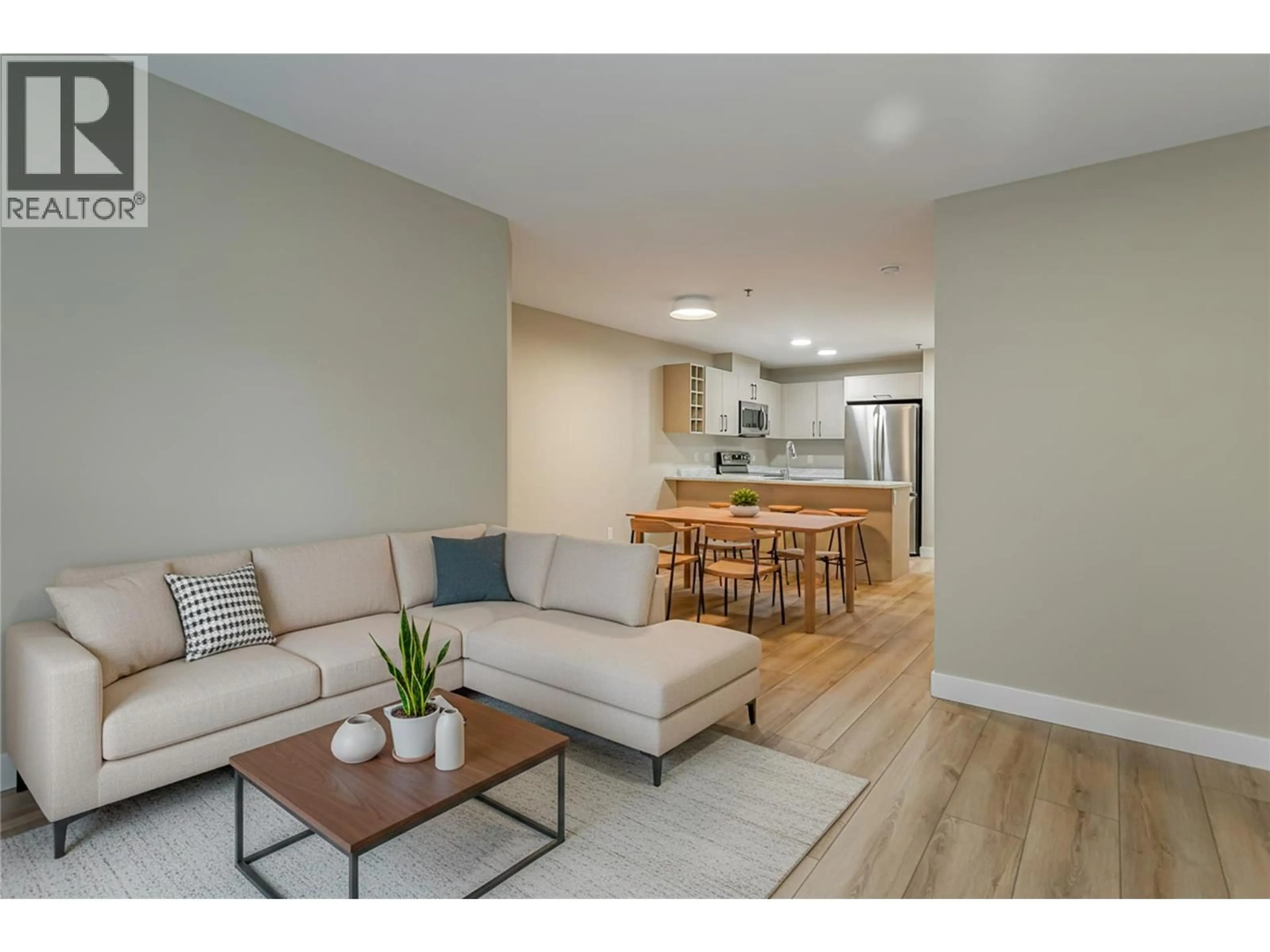 Living room with furniture, wood/laminate floor for 230 - 1099 SUNSET DRIVE, Kelowna British Columbia V1Y9Z2