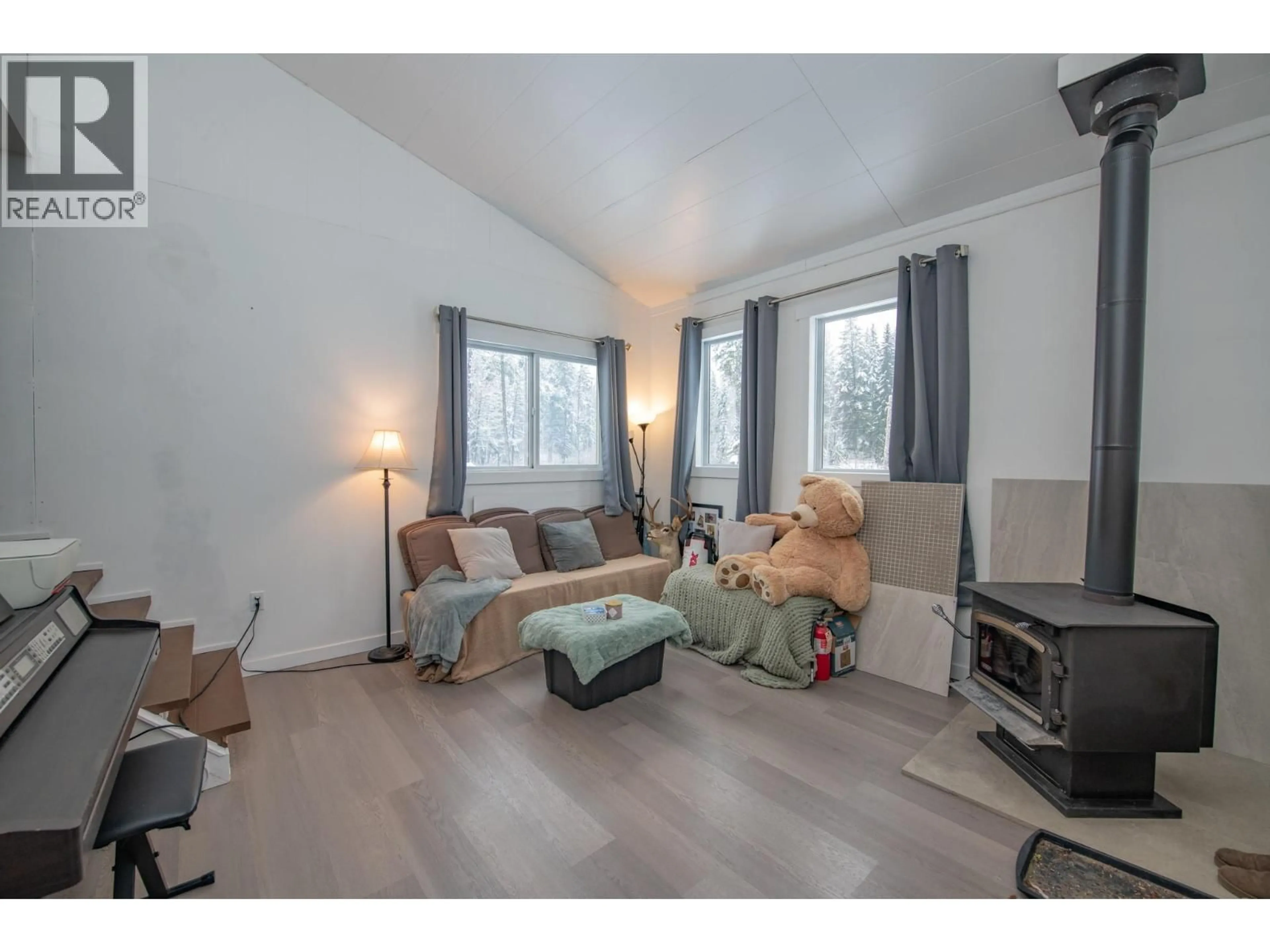 Living room with furniture, wood/laminate floor for 6739 KARJULA ROAD, Falkland British Columbia V0E1W1