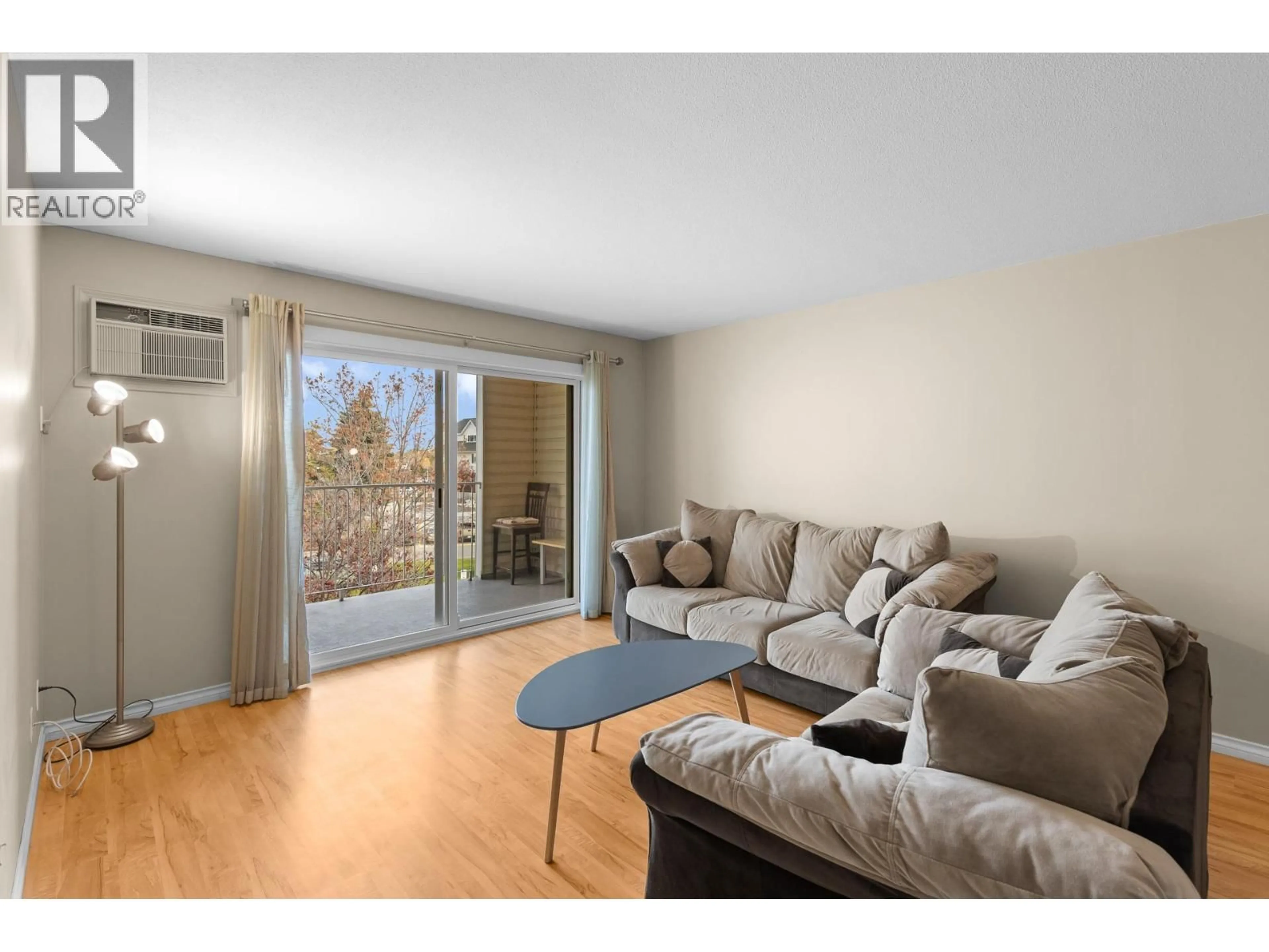 Living room with furniture, wood/laminate floor for 308 - 3163 RICHTER STREET, Kelowna British Columbia V1W3R4