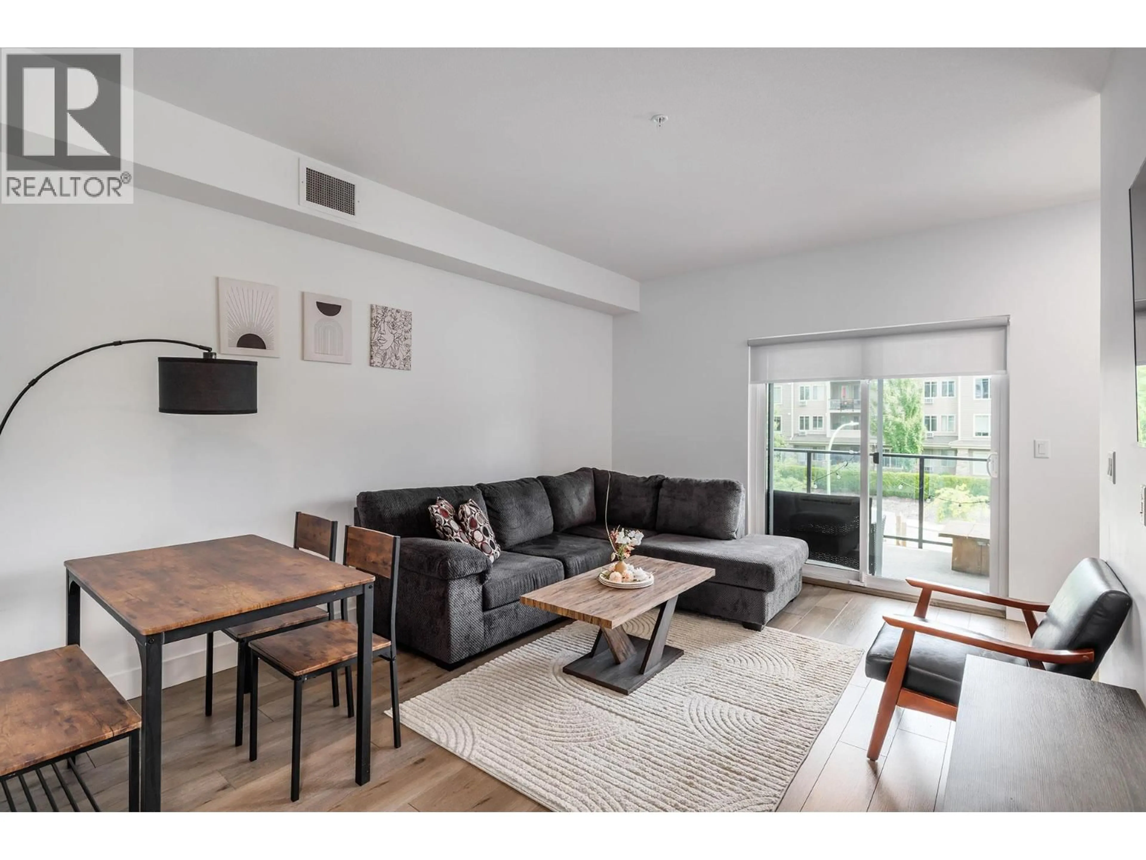 Living room with furniture, wood/laminate floor for 303 - 3642 MISSION SPRINGS DRIVE, Kelowna British Columbia V1W0E1