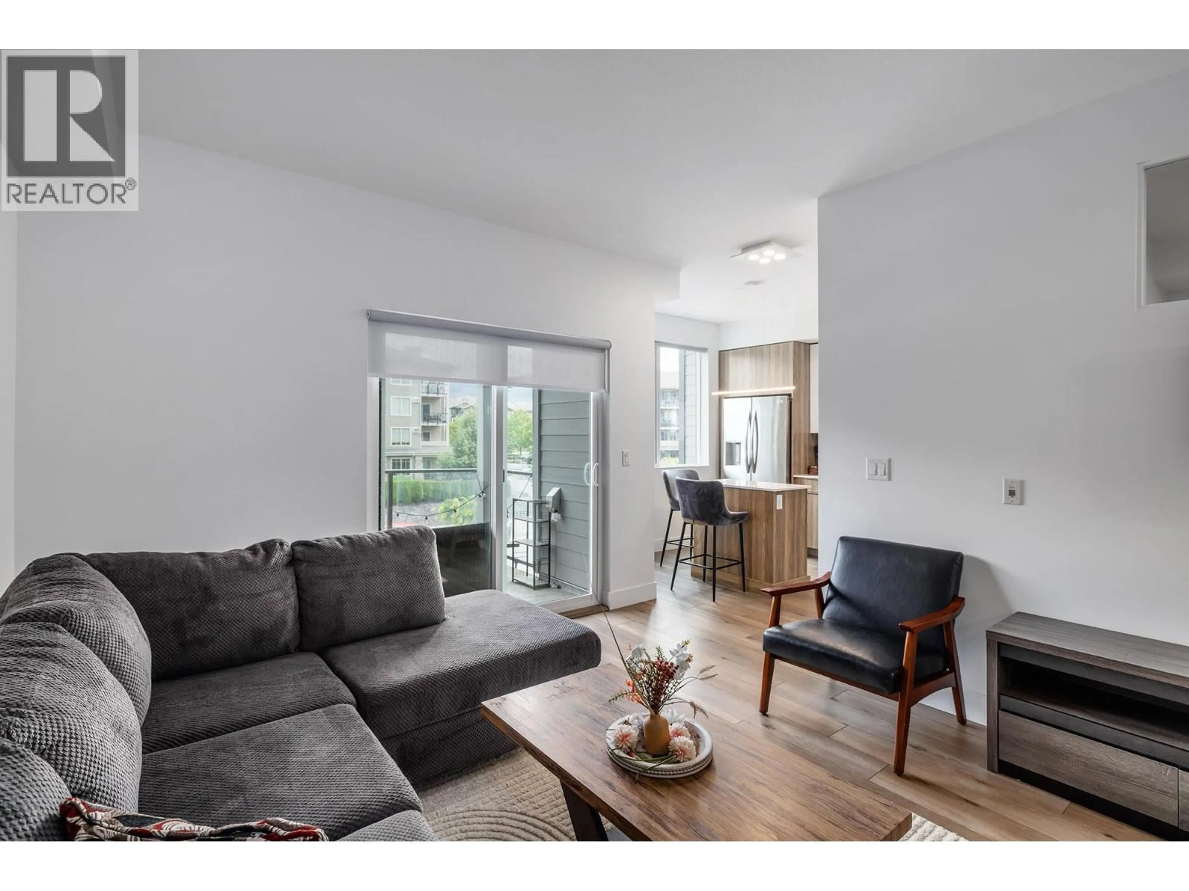 Living room with furniture, wood/laminate floor for 303 - 3642 MISSION SPRINGS DRIVE, Kelowna British Columbia V1W0E1