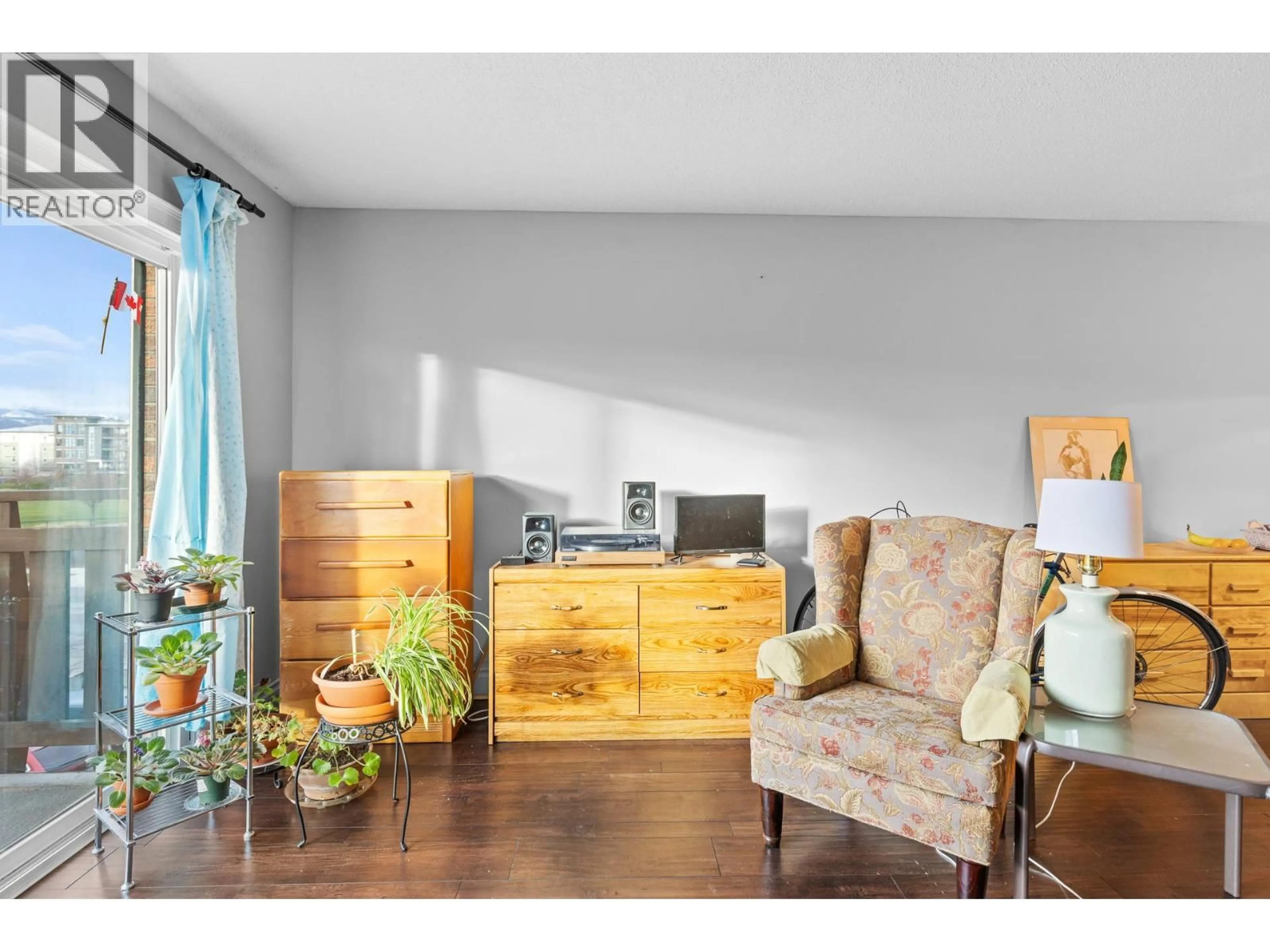 Living room with furniture, wood/laminate floor for 204 - 1860 RICHTER STREET, Kelowna British Columbia V1Y2M9