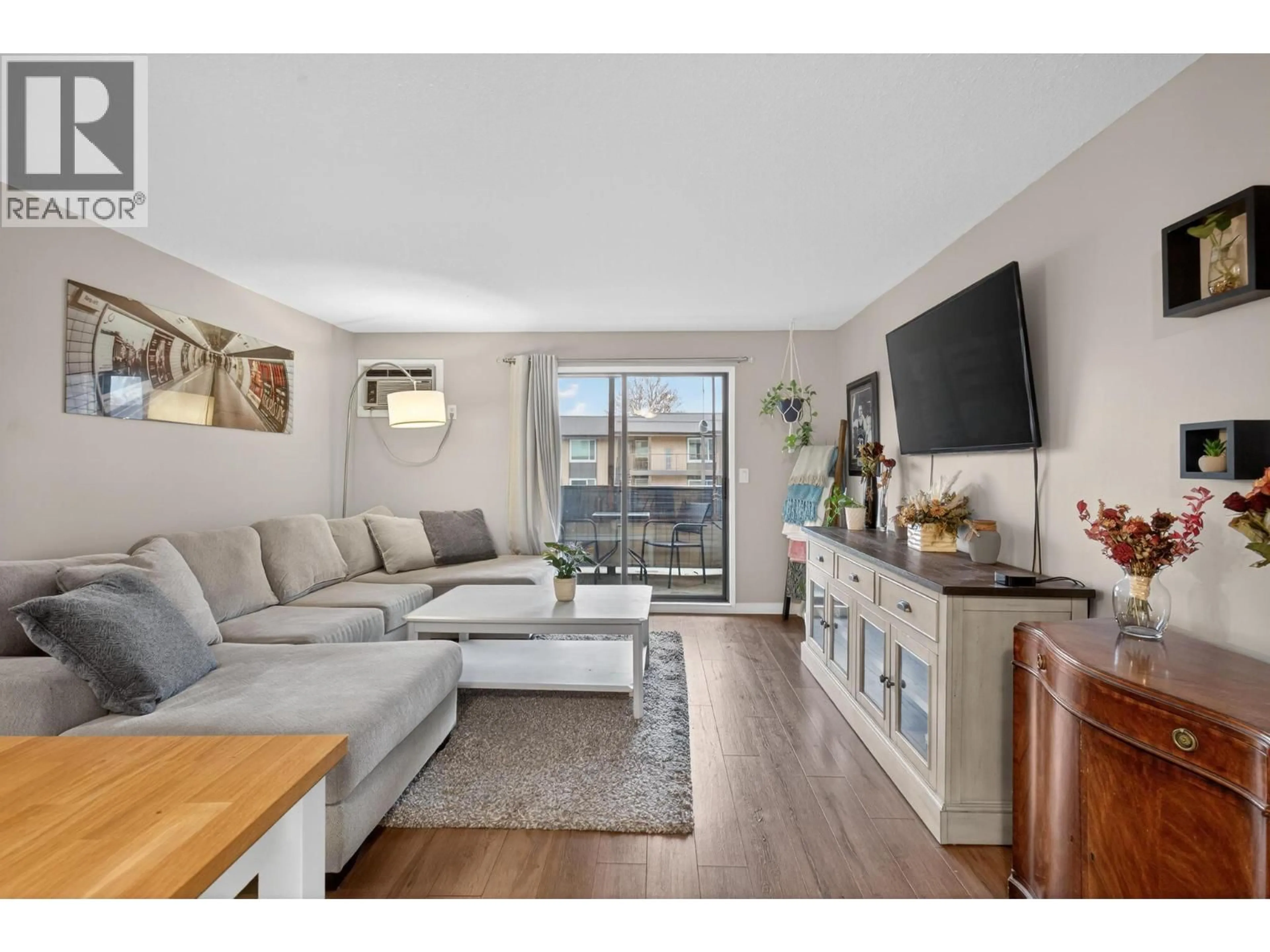 Living room with furniture, wood/laminate floor for 114 - 1640 UFTON COURT, Kelowna British Columbia V1Y8L5