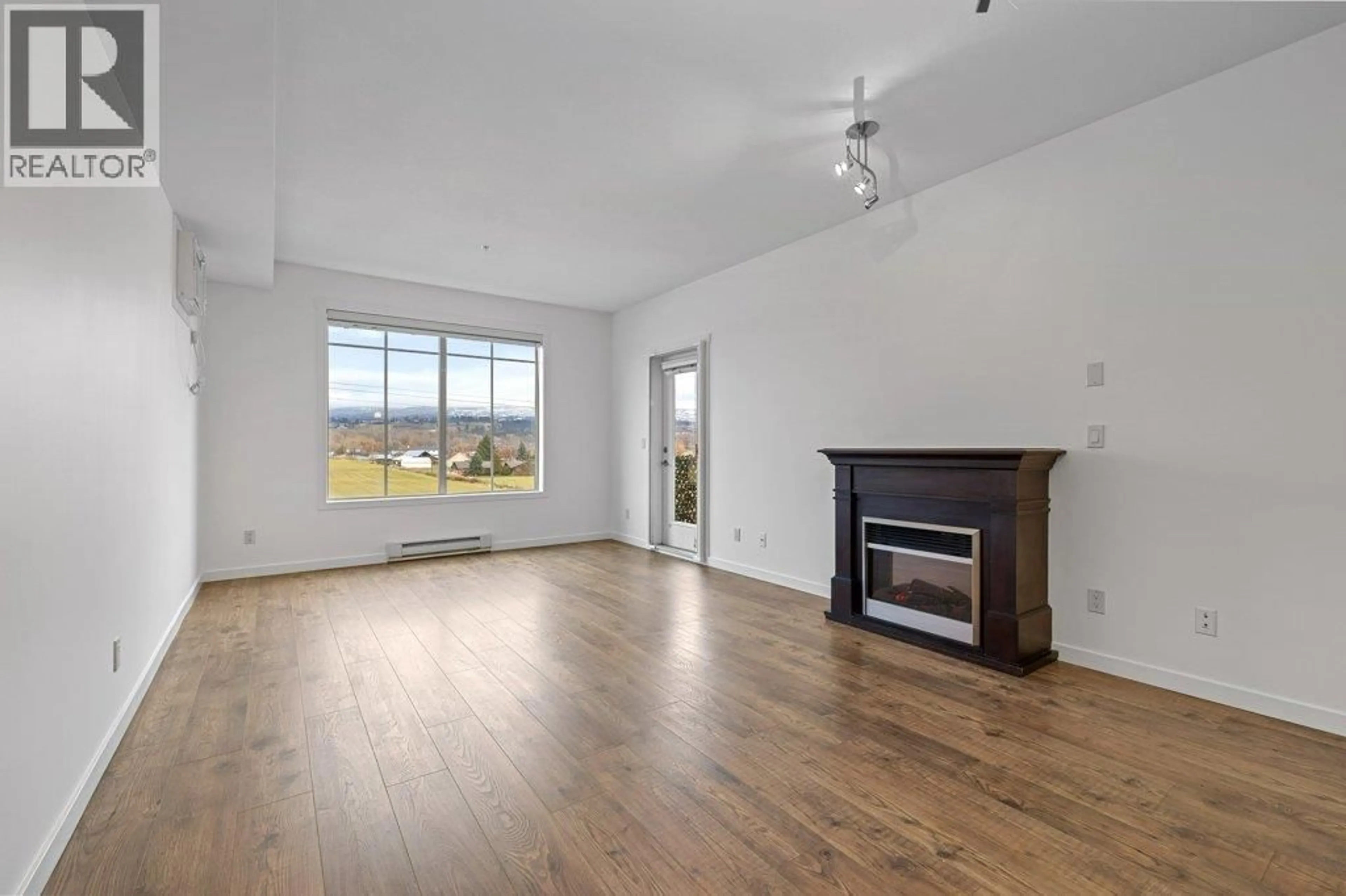Living room with furniture, wood/laminate floor for 305 - 3735 CASORSO ROAD, Kelowna British Columbia V1W5G1