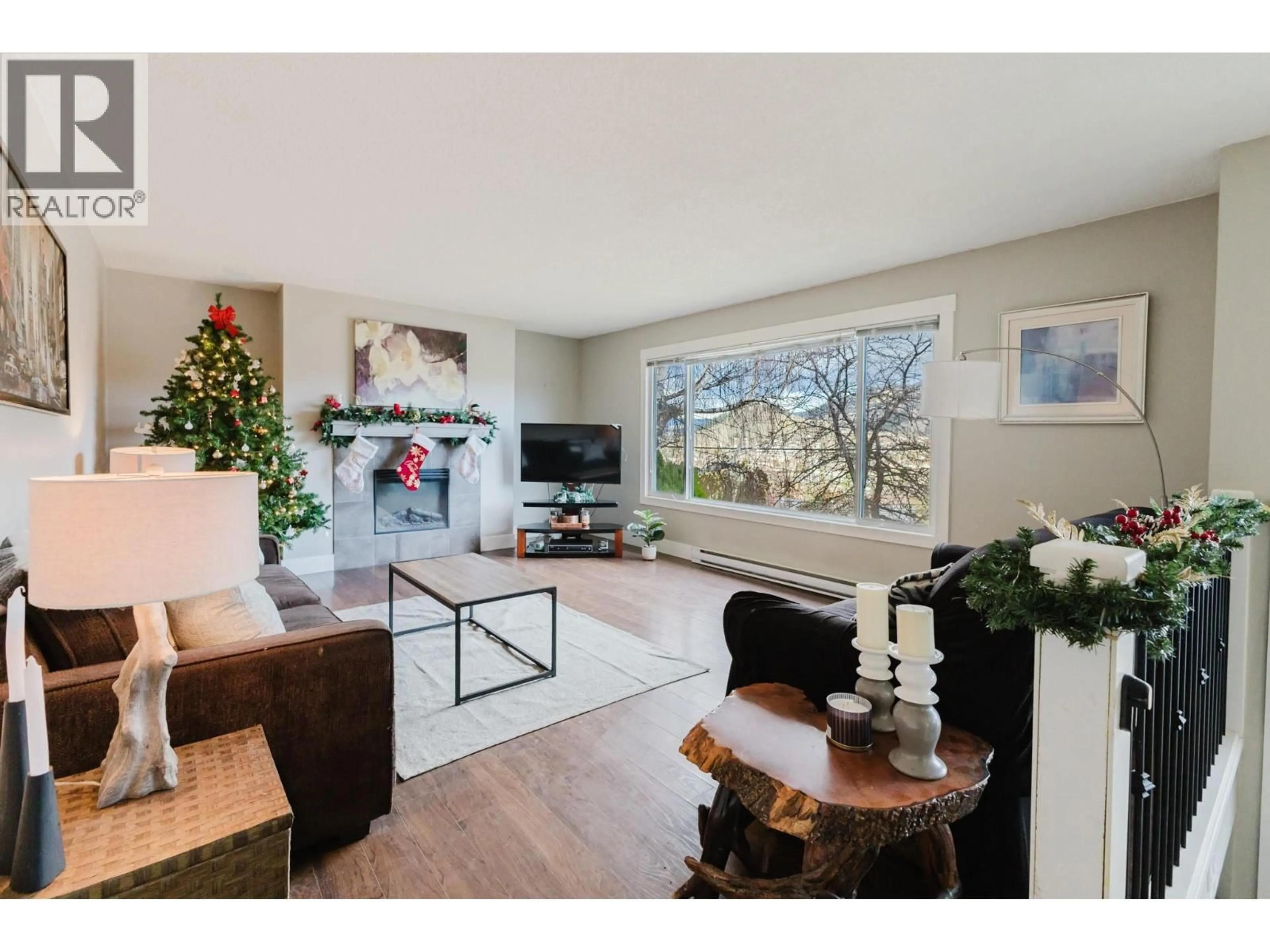 Living room with furniture, wood/laminate floor for 2126 VERDE VISTA ROAD, Kelowna British Columbia V1P1G5