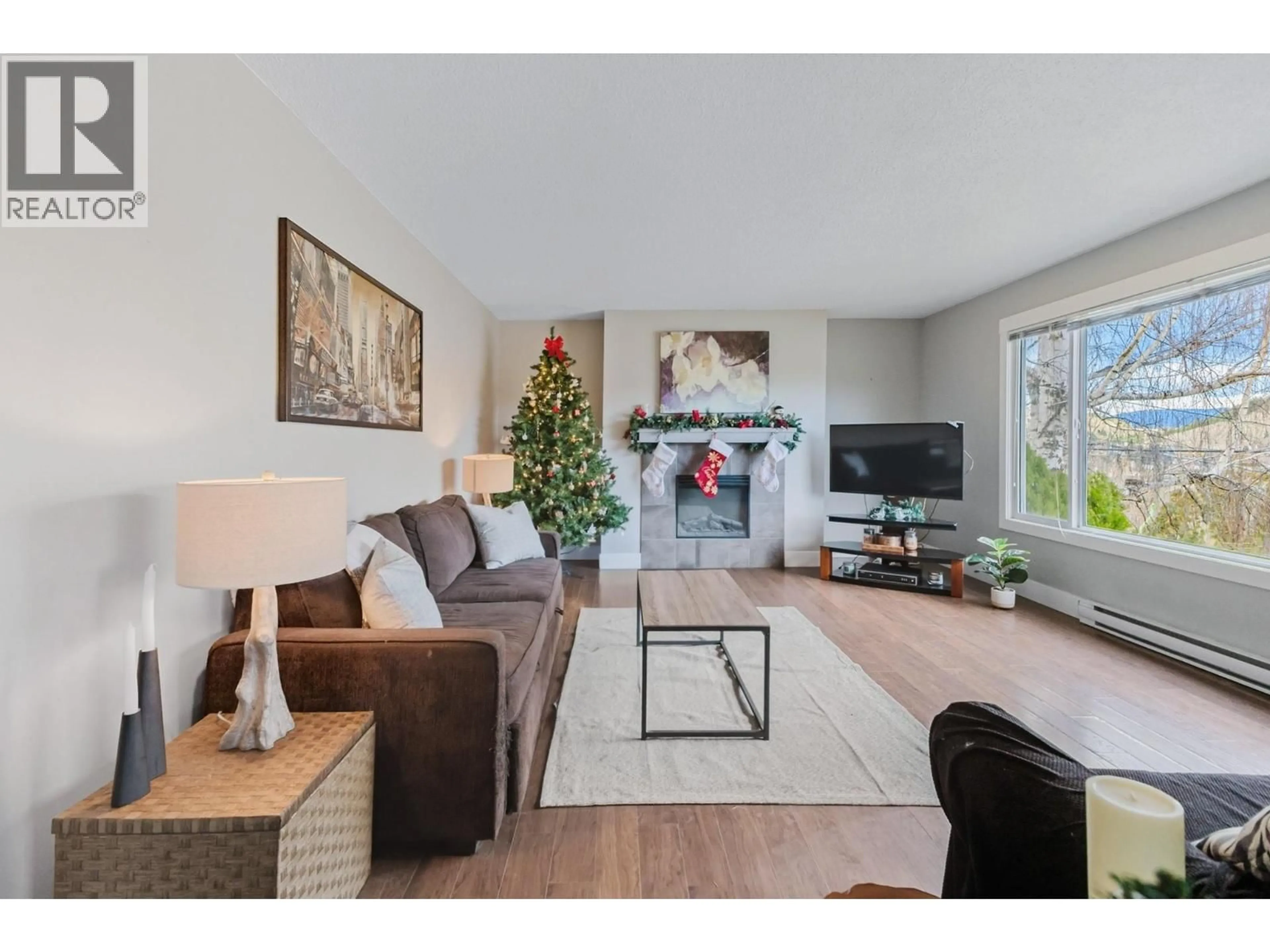 Living room with furniture, wood/laminate floor for 2126 VERDE VISTA ROAD, Kelowna British Columbia V1P1G5