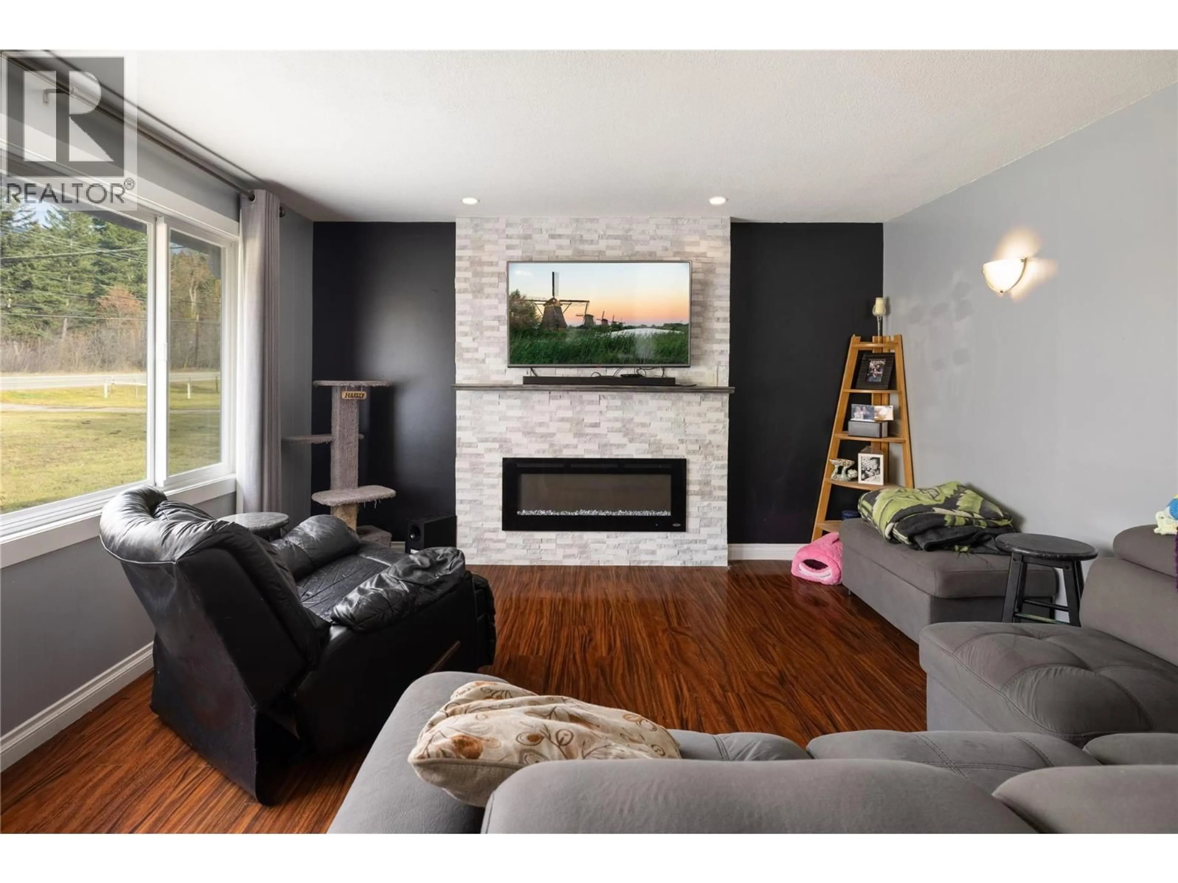 Living room with furniture, wood/laminate floor for 5712 6 HIGHWAY, Vernon British Columbia V1B3E1