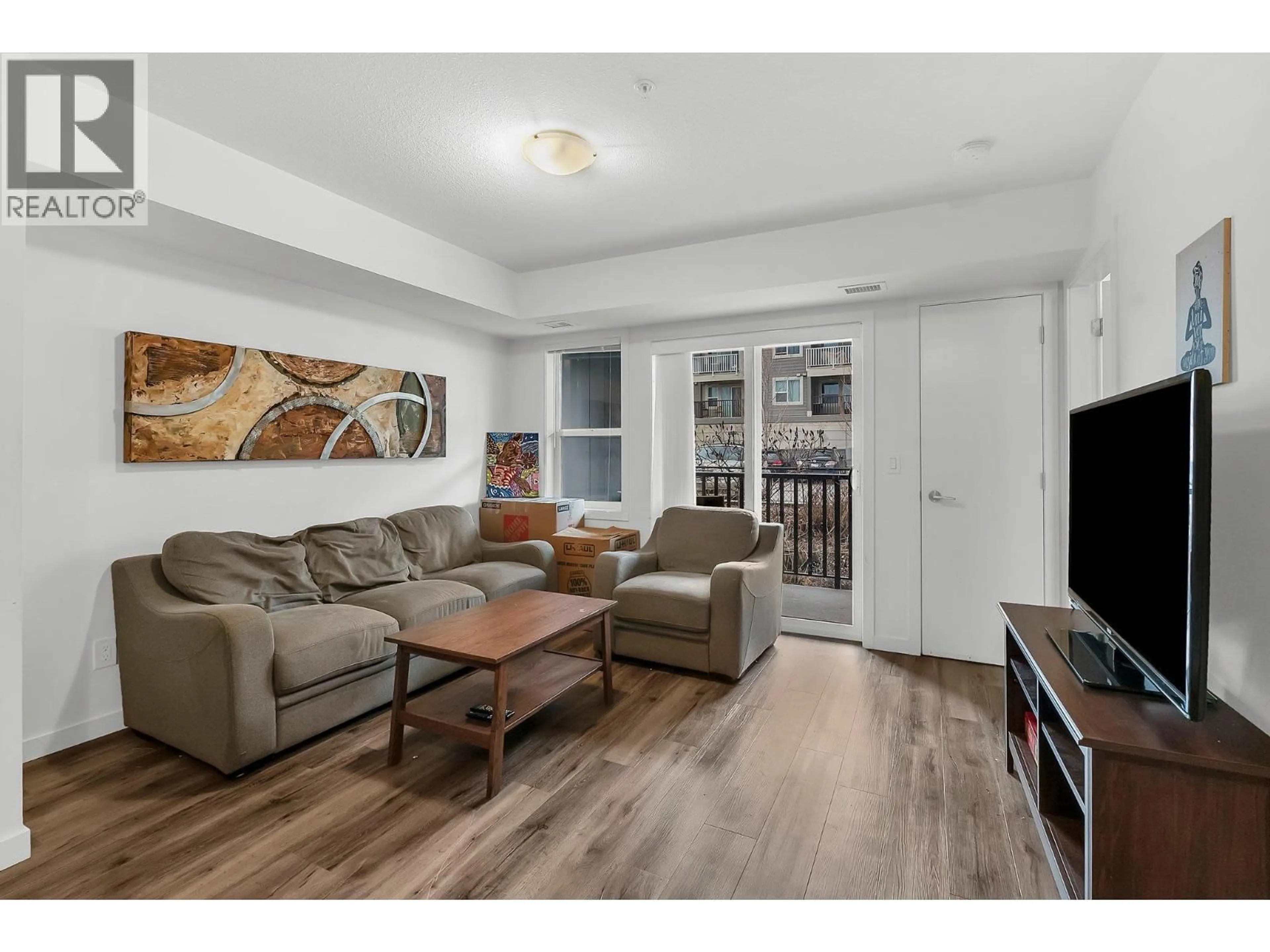 Living room with furniture, wood/laminate floor for 211 - 655 ACADEMY WAY, Kelowna British Columbia V1V0A2