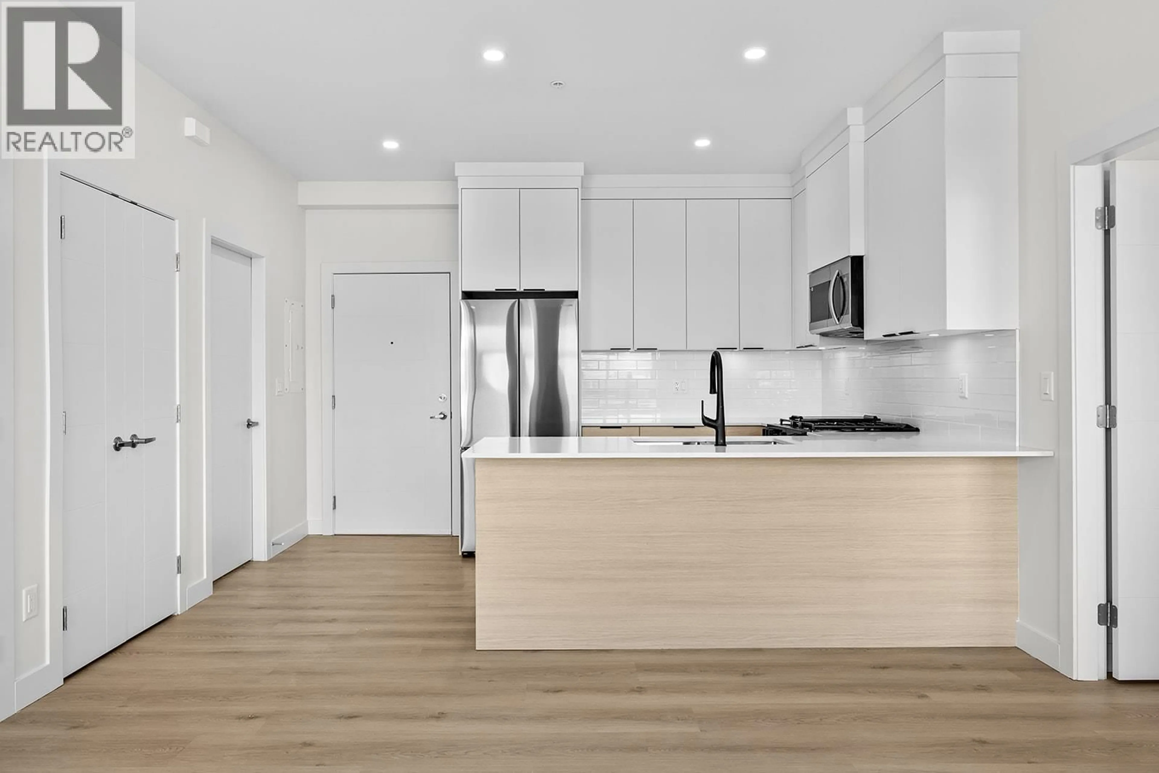 Open concept kitchen, wood/laminate floor for 203 - 5300 MAIN STREET, Kelowna British Columbia V1W0C1