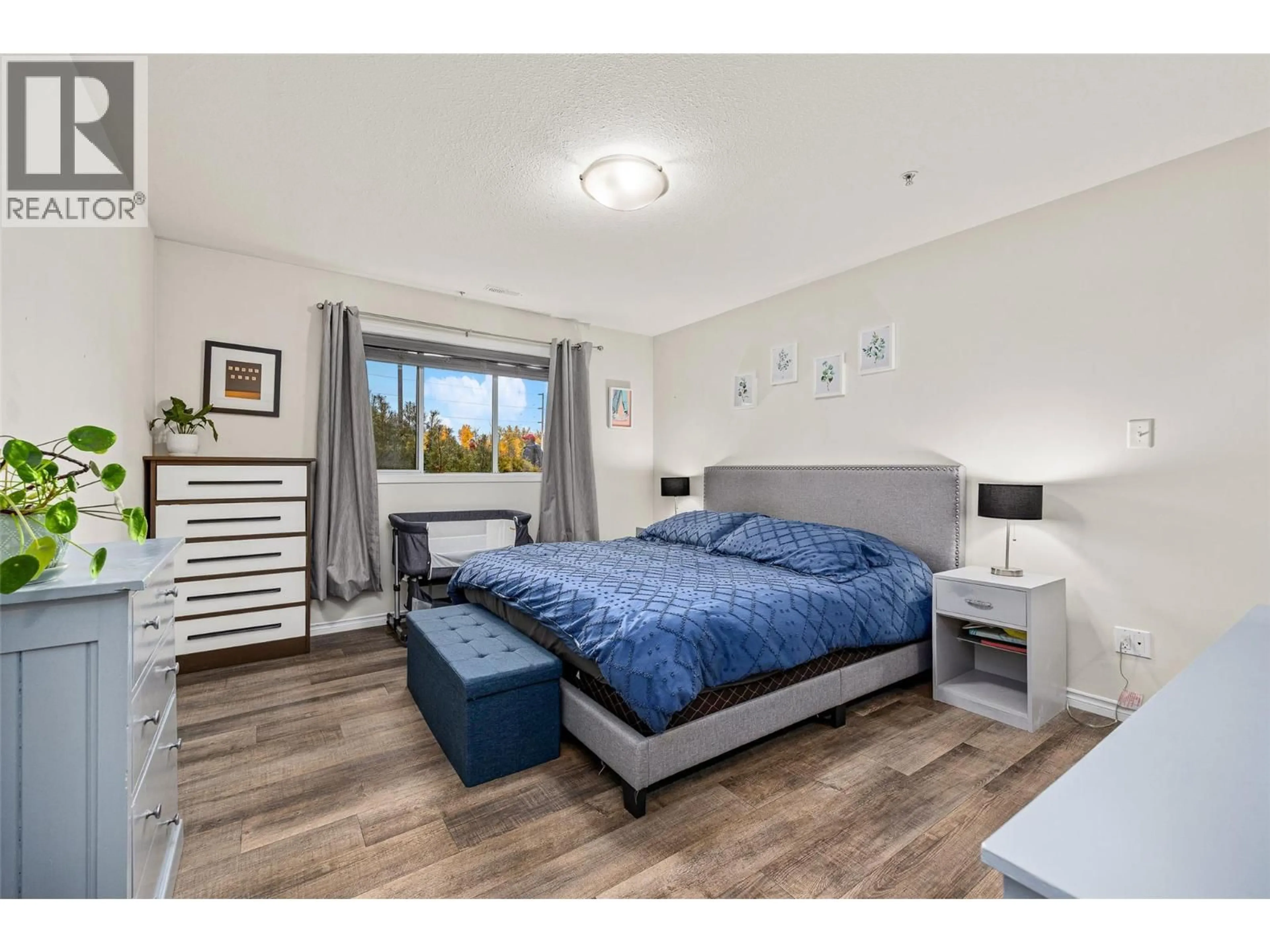 Bedroom with bed, wood/laminate floor for 104 - 1966 DURNIN ROAD, Kelowna British Columbia V1X7Z2