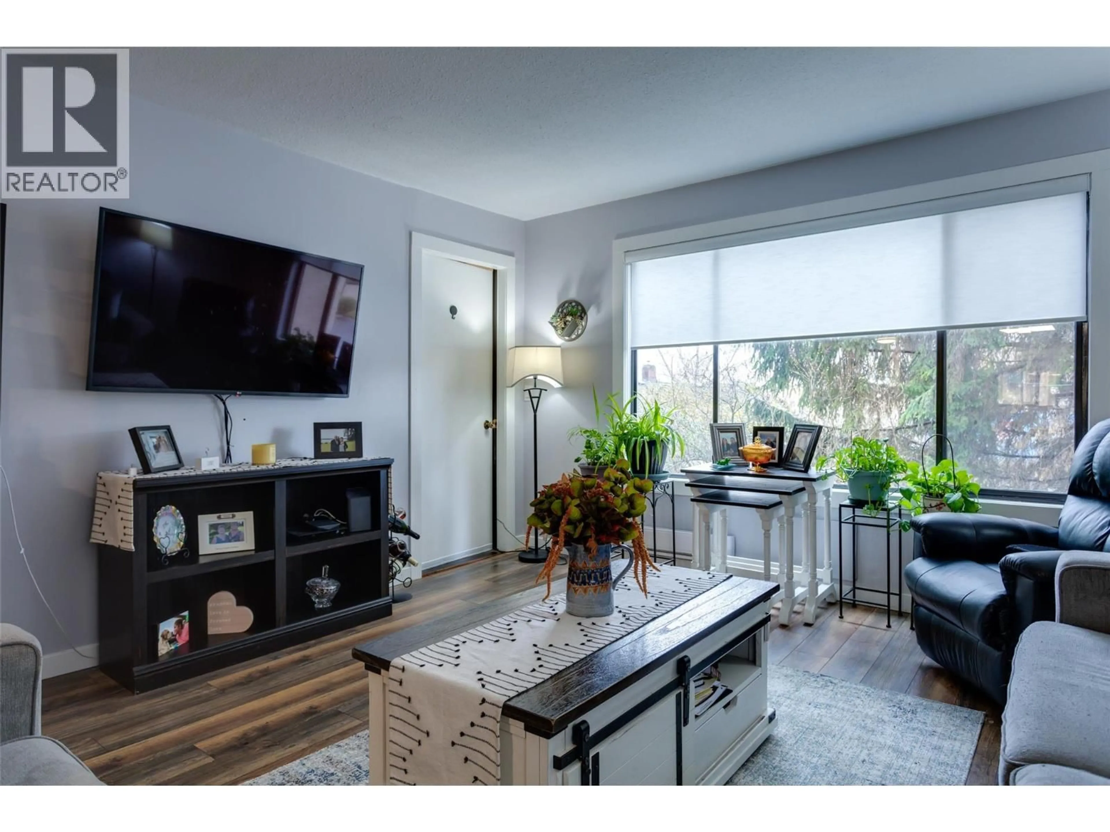 Living room with furniture, wood/laminate floor for 103 - 1903 LINDAHL STREET, Kelowna British Columbia V1Y3Z6
