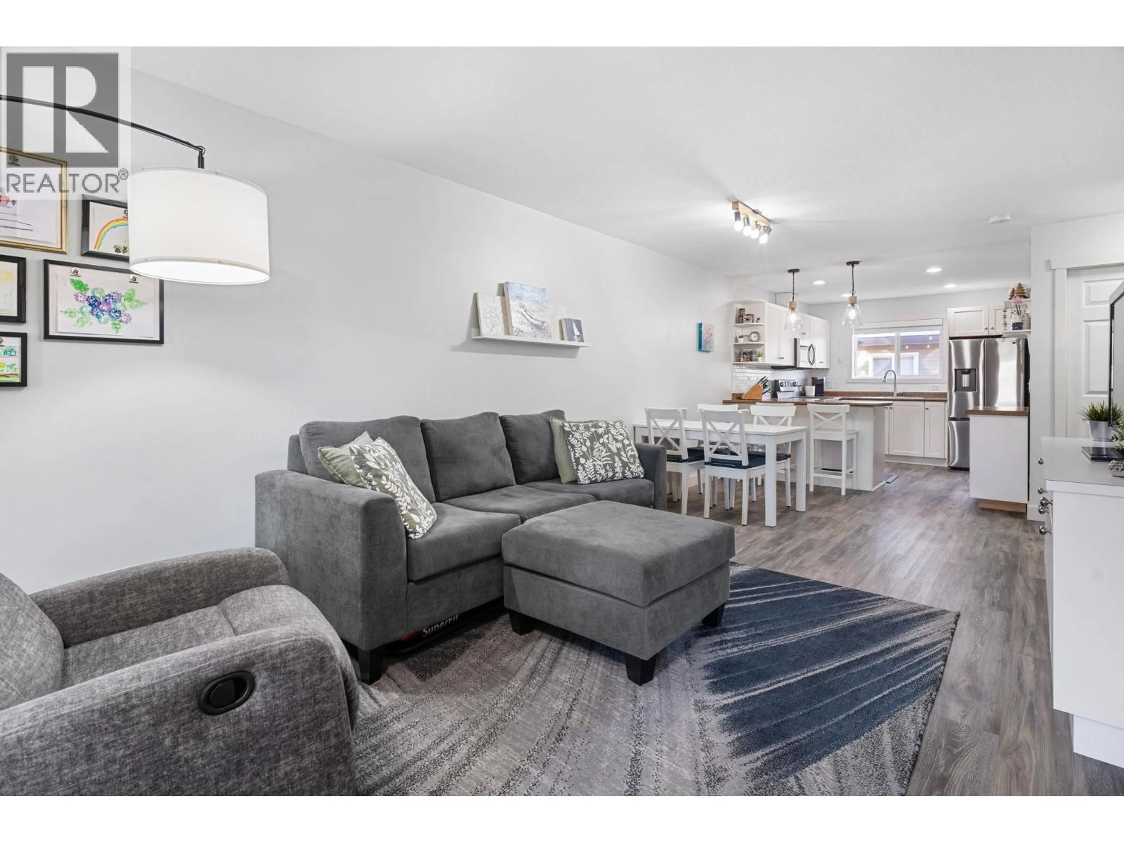 Living room with furniture, wood/laminate floor for 128 - 1355 FINDLAY ROAD, Kelowna British Columbia V1X8B8