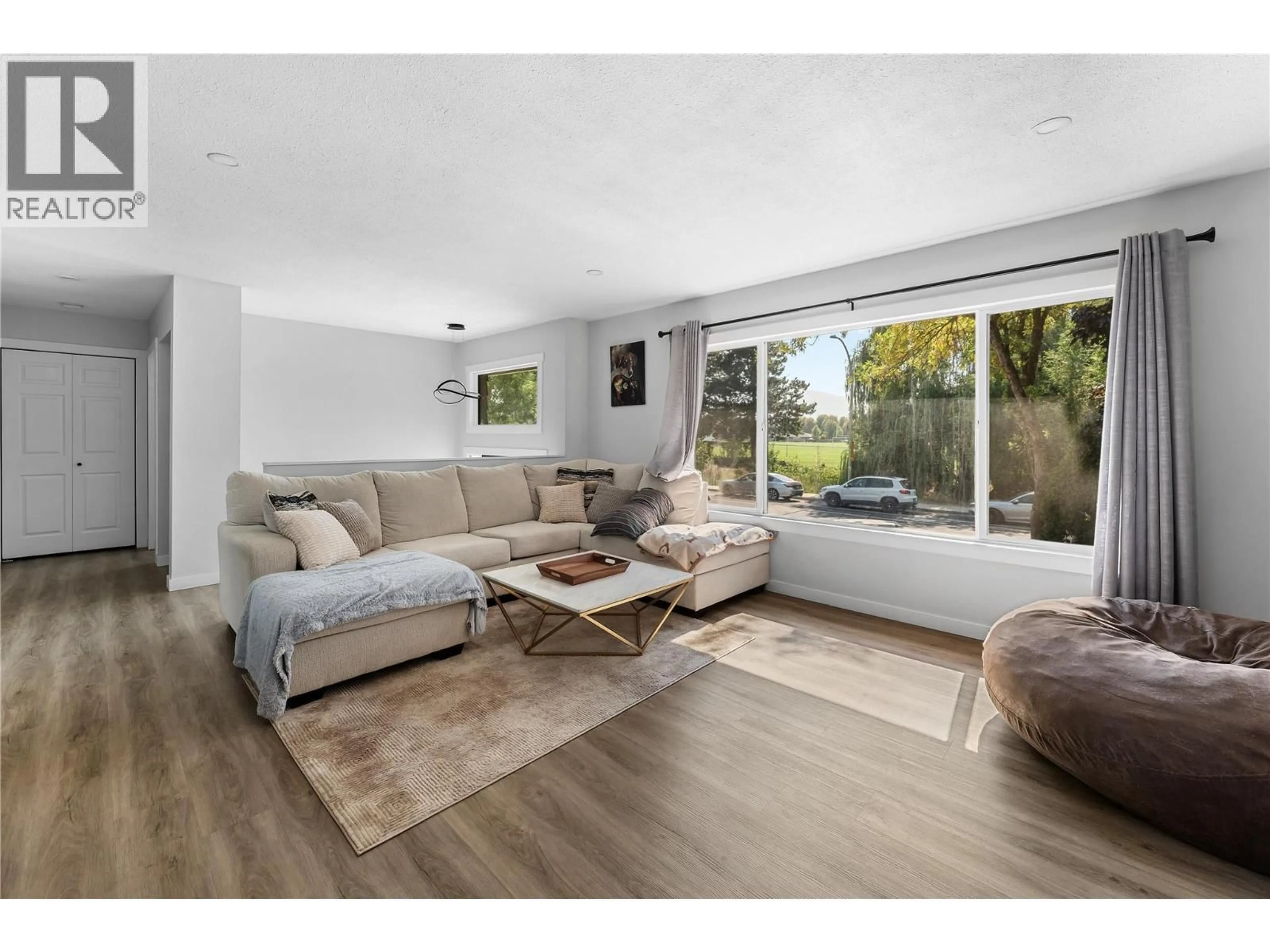 Living room with furniture, wood/laminate floor for 950 RAYMER AVENUE, Kelowna British Columbia V1Y4Z9