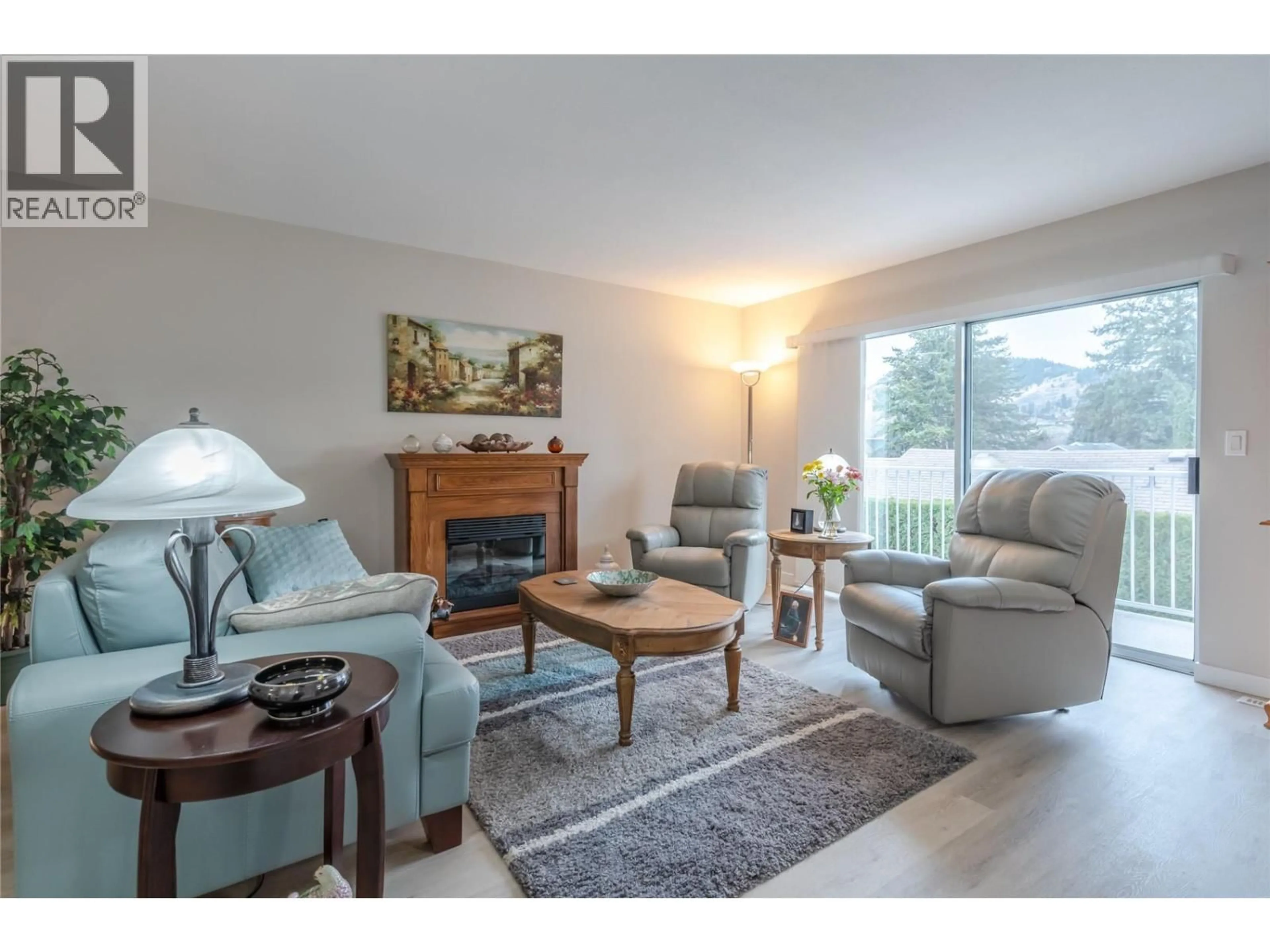Living room with furniture, wood/laminate floor for 3 - 14615 VICTORIA ROAD NORTH, Summerland British Columbia V0H1Z5