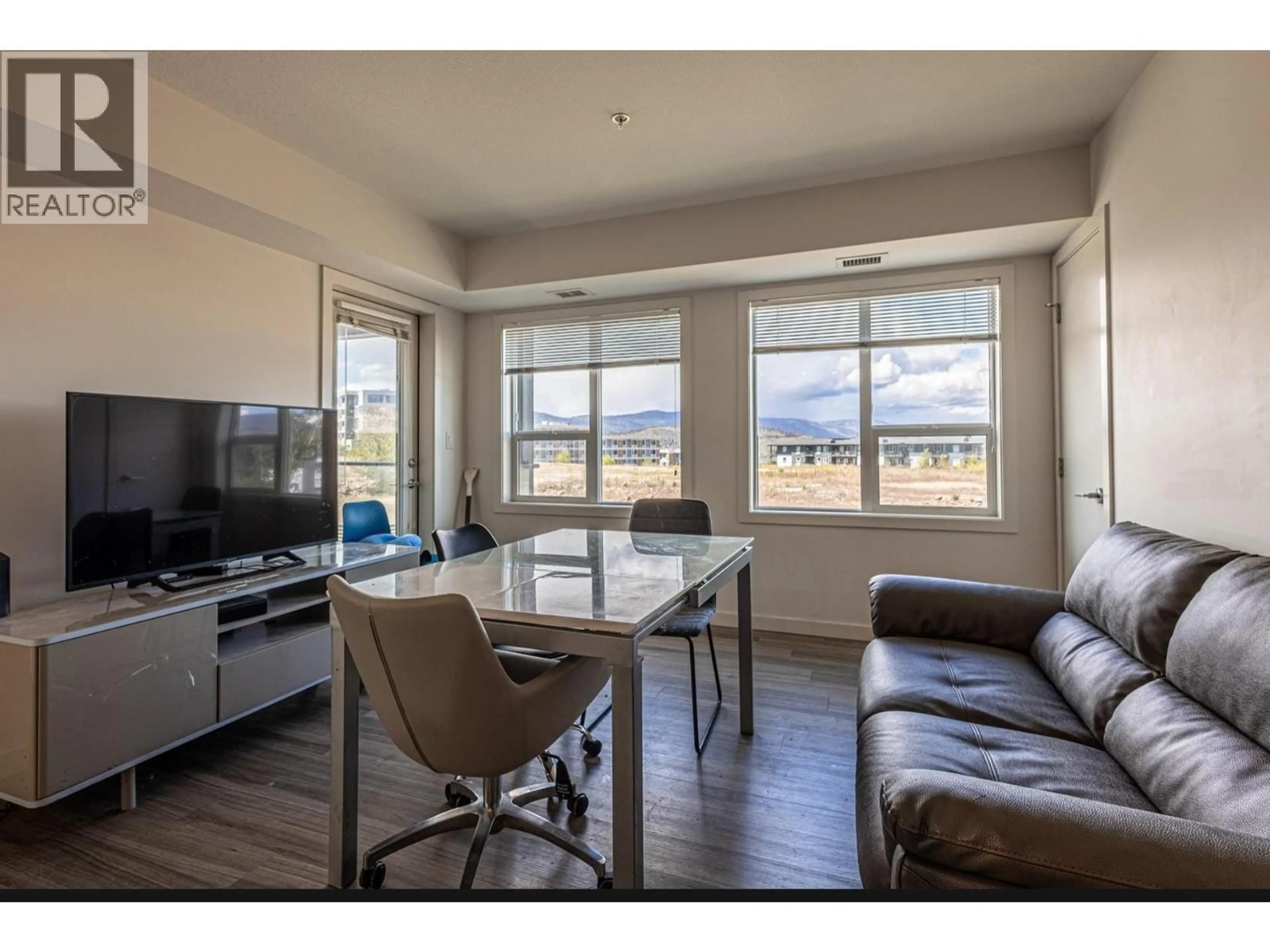 Living room with furniture, wood/laminate floor for 207 - 775 ACADEMY WAY, Kelowna British Columbia V7V0A5