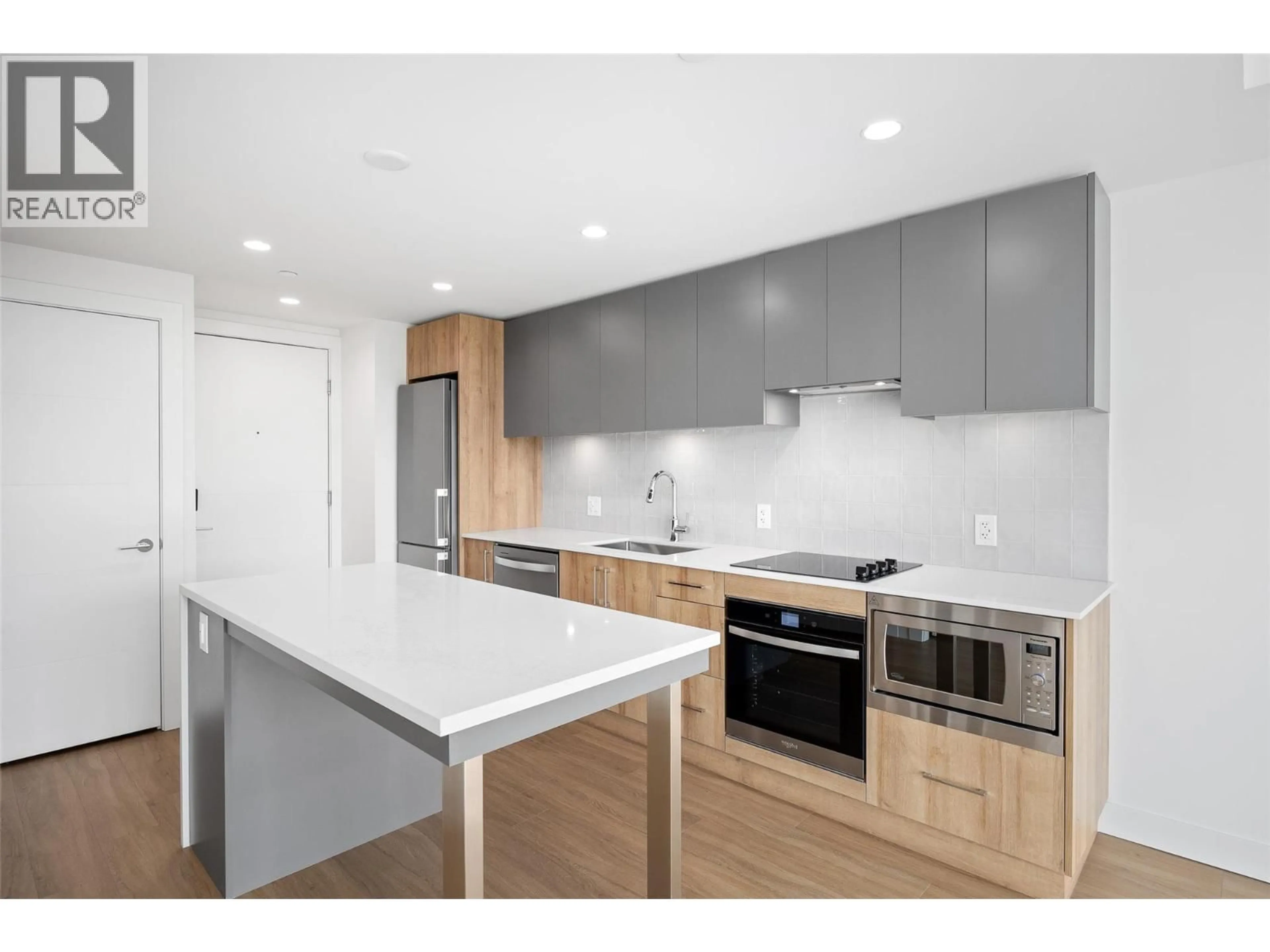 Open concept kitchen, wood/laminate floor for 705 - 3699 CAPOZZI ROAD, Kelowna British Columbia V1W3L2