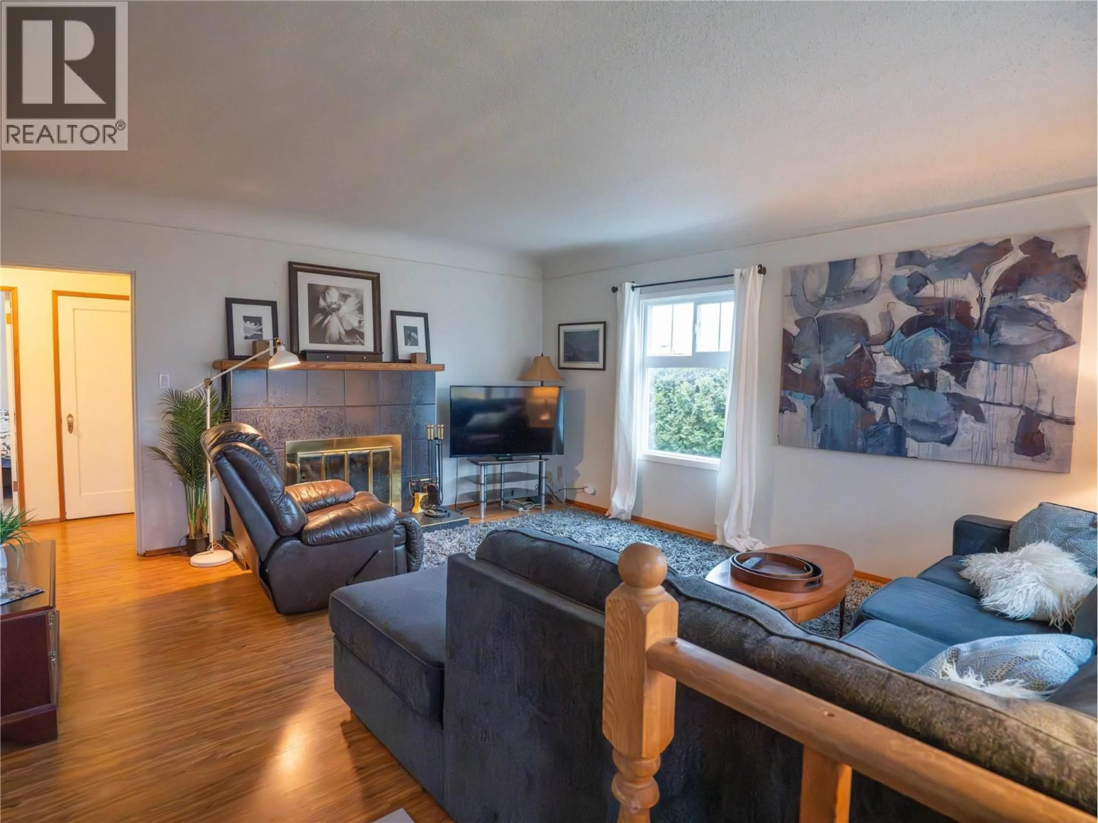 Living room with furniture, wood/laminate floor for 416 TENNIS STREET, Penticton British Columbia V2A5R3