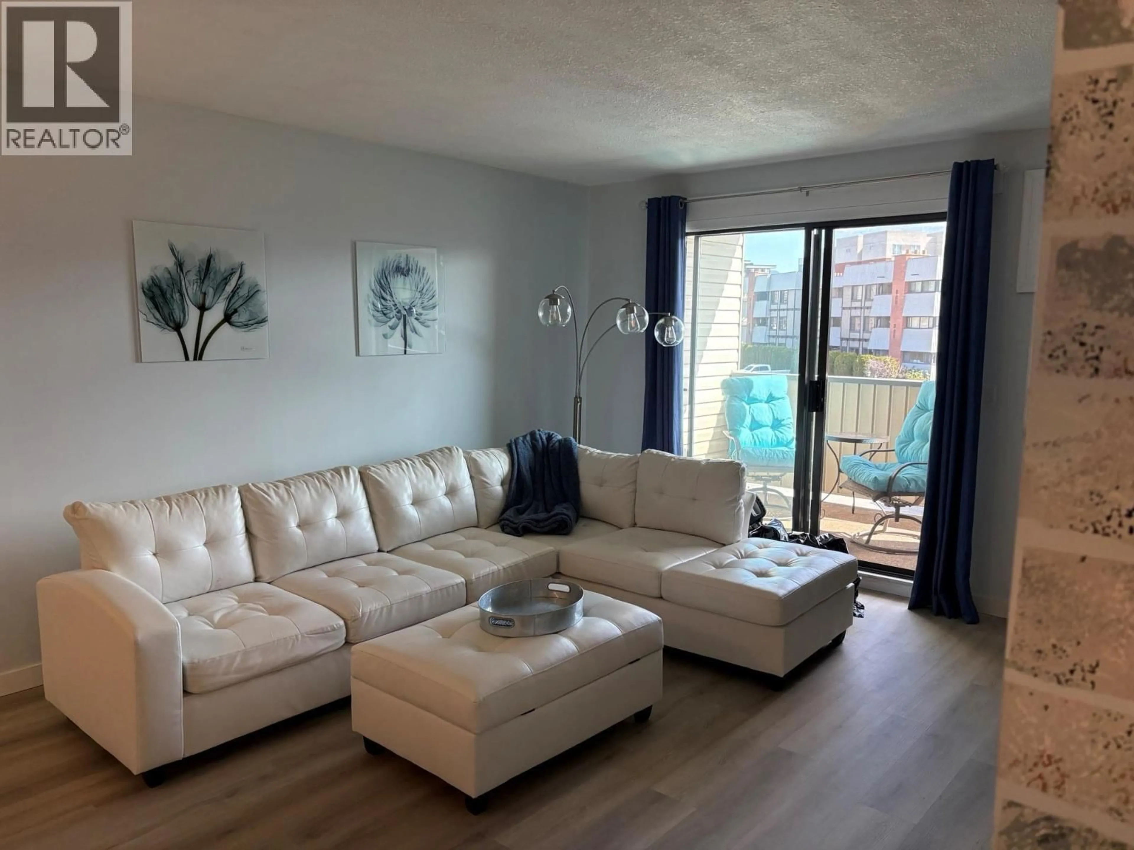 Living room with furniture, wood/laminate floor for 211 - 1640 UFTON COURT, Kelowna British Columbia V1Y8L5