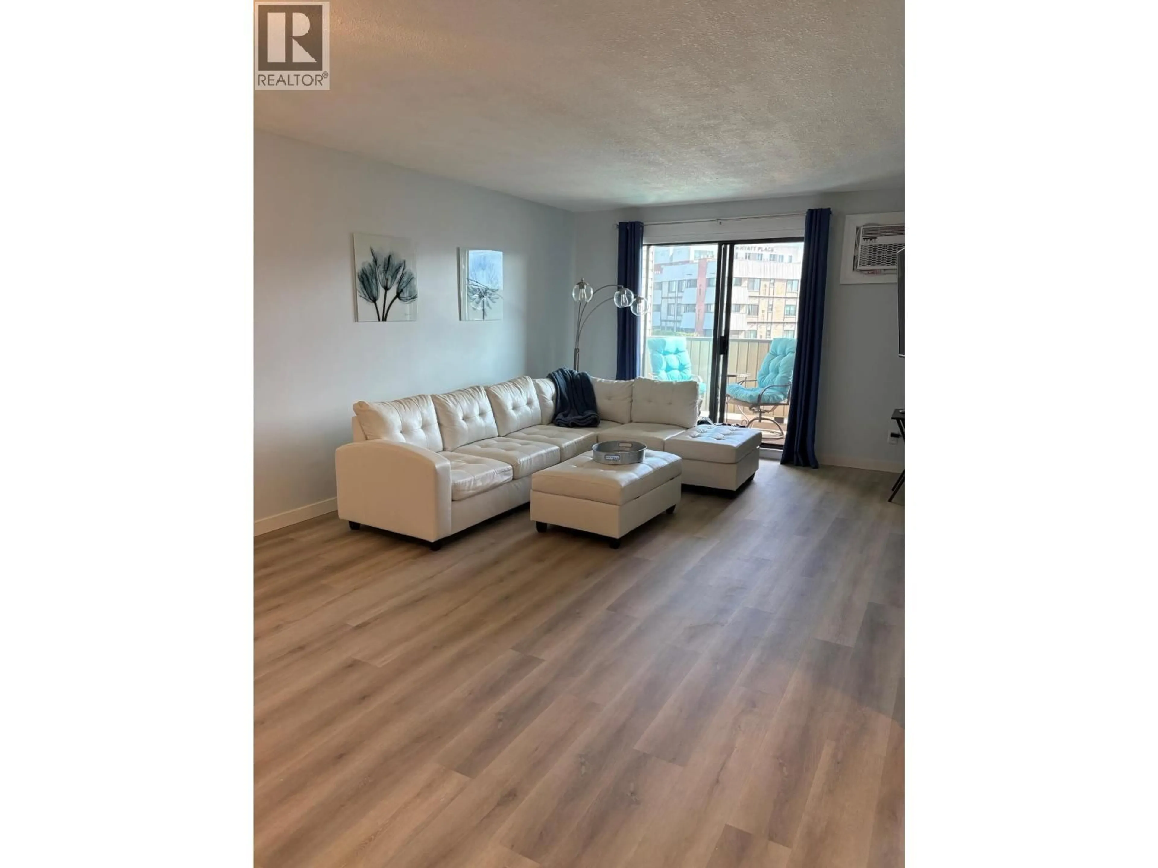 Living room with furniture, wood/laminate floor for 211 - 1640 UFTON COURT, Kelowna British Columbia V1Y8L5