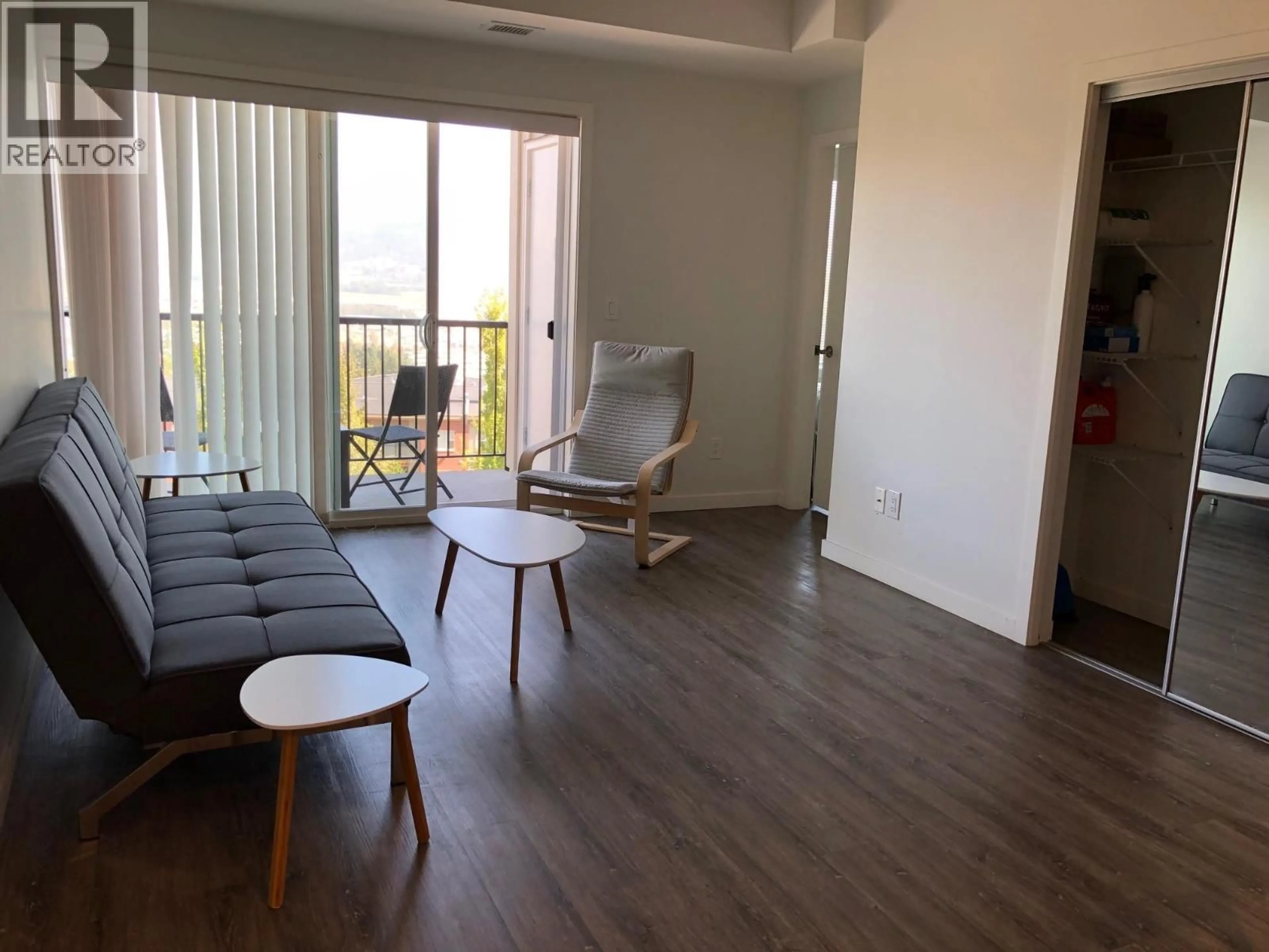 Living room with furniture, wood/laminate floor for 303 - 935 ACADEMY WAY, Kelowna British Columbia V1V3C9