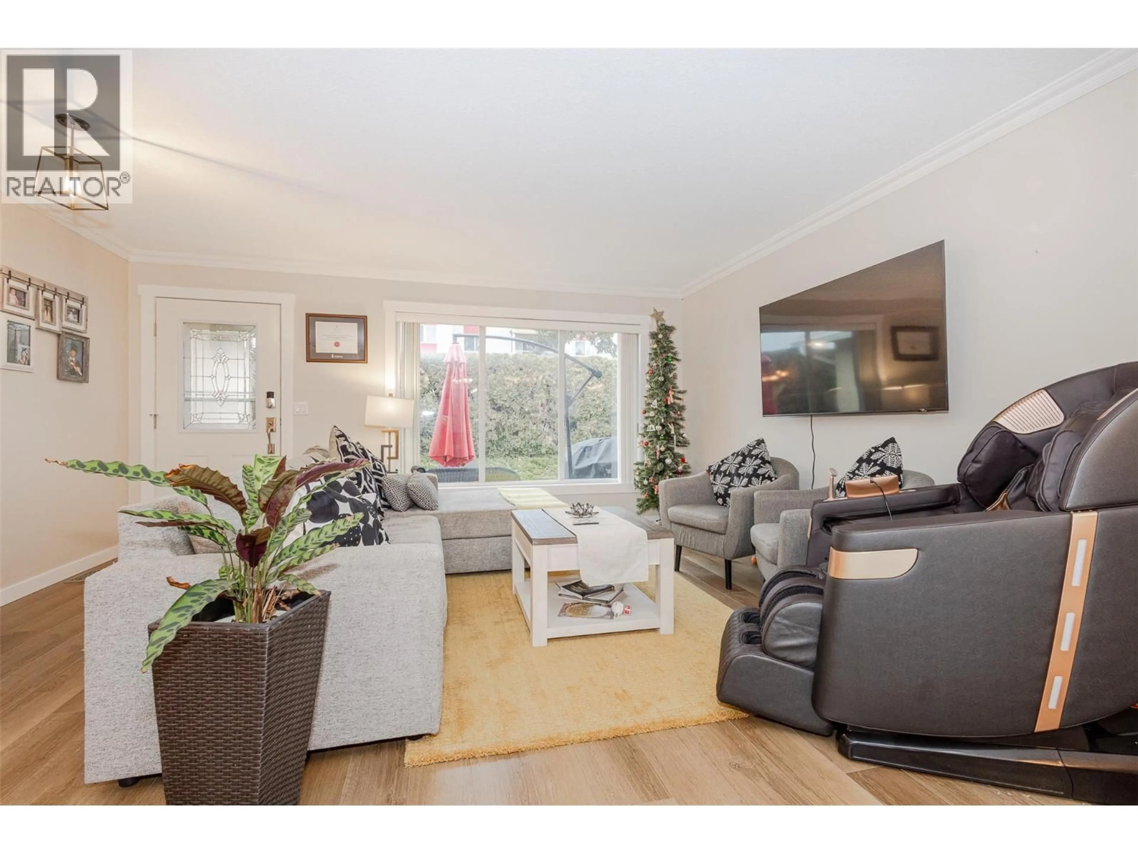 Living room with furniture, wood/laminate floor for 1 - 205 GERSTMAR ROAD, Kelowna British Columbia V1X4A6