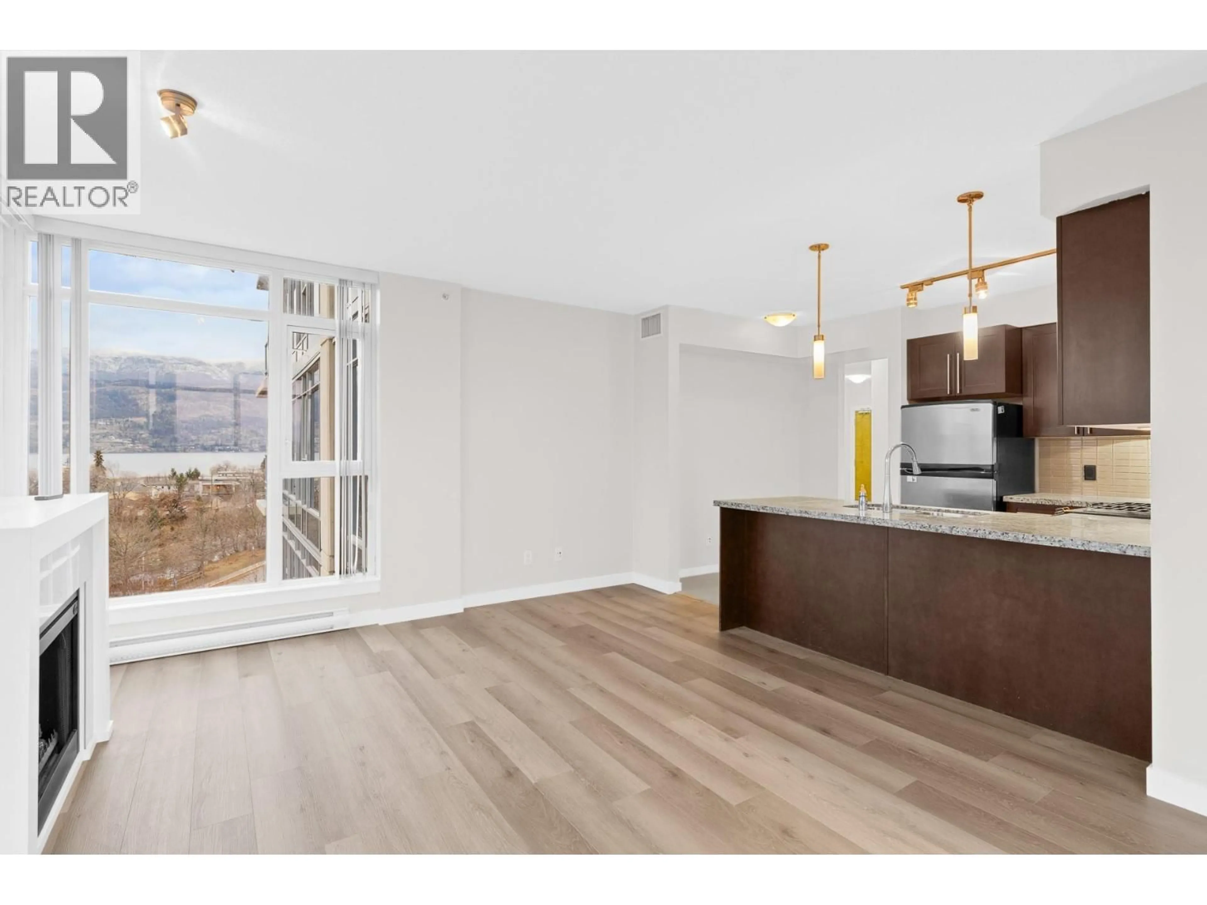 Open concept kitchen, wood/laminate floor for 706 - 1075 SUNSET DRIVE, Kelowna British Columbia V1Y6Y6