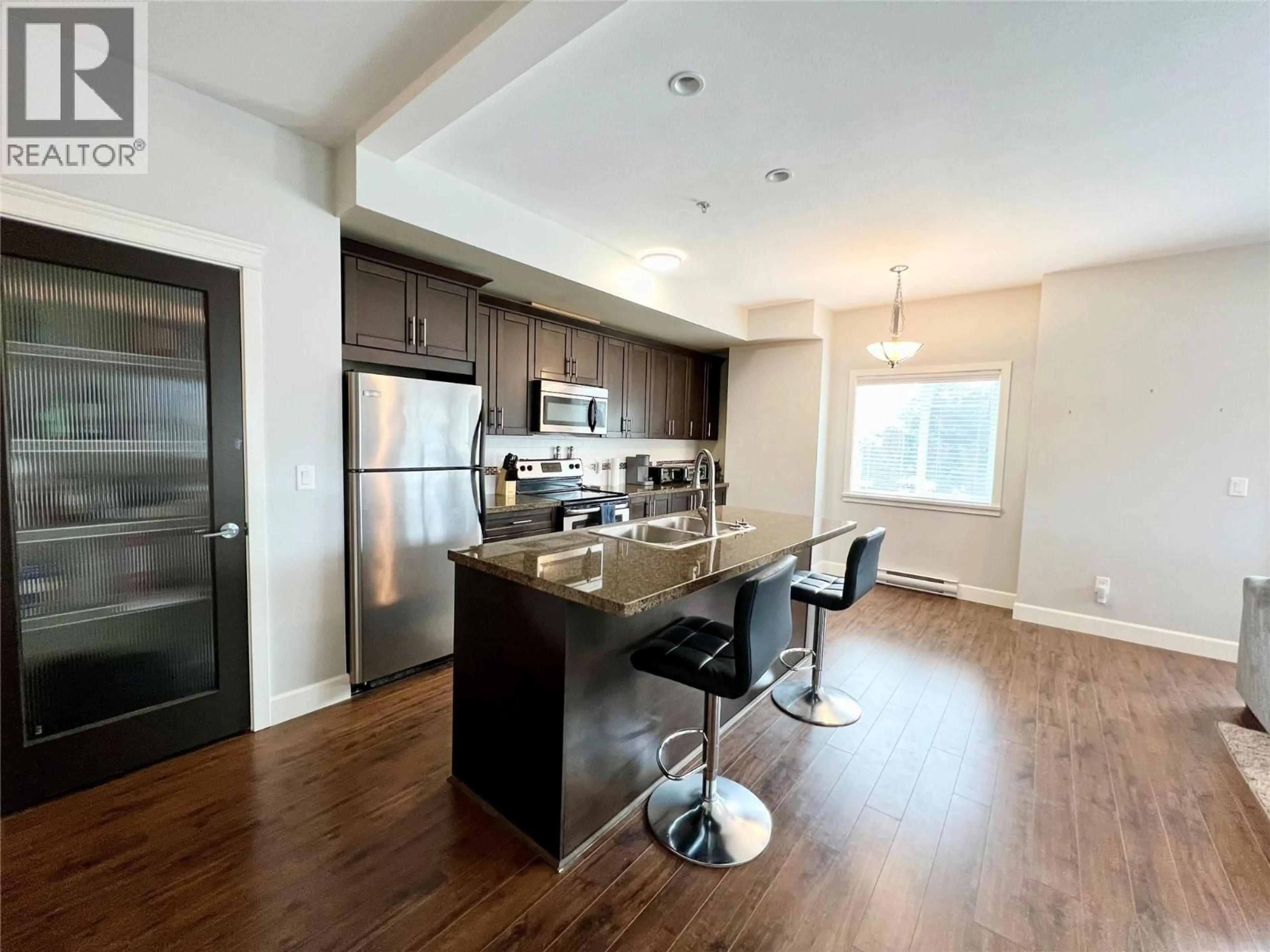 Open concept kitchen, wood/laminate floor for 206 - 2799 CLAPPERTON AVENUE, Merritt British Columbia V1K1A2