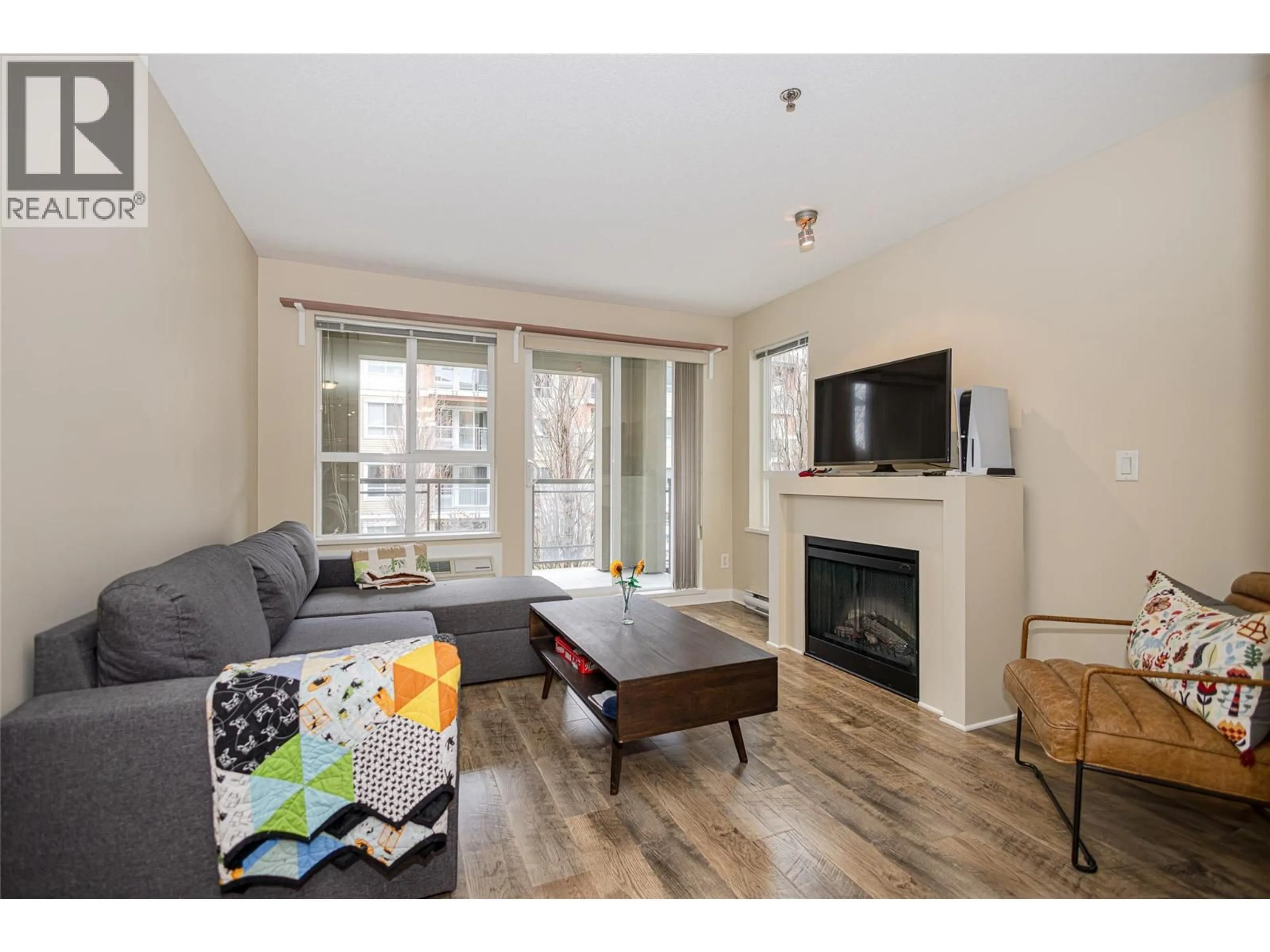 Living room with furniture, wood/laminate floor for 203 - 1093 SUNSET DRIVE, Kelowna British Columbia V1Y9Z4