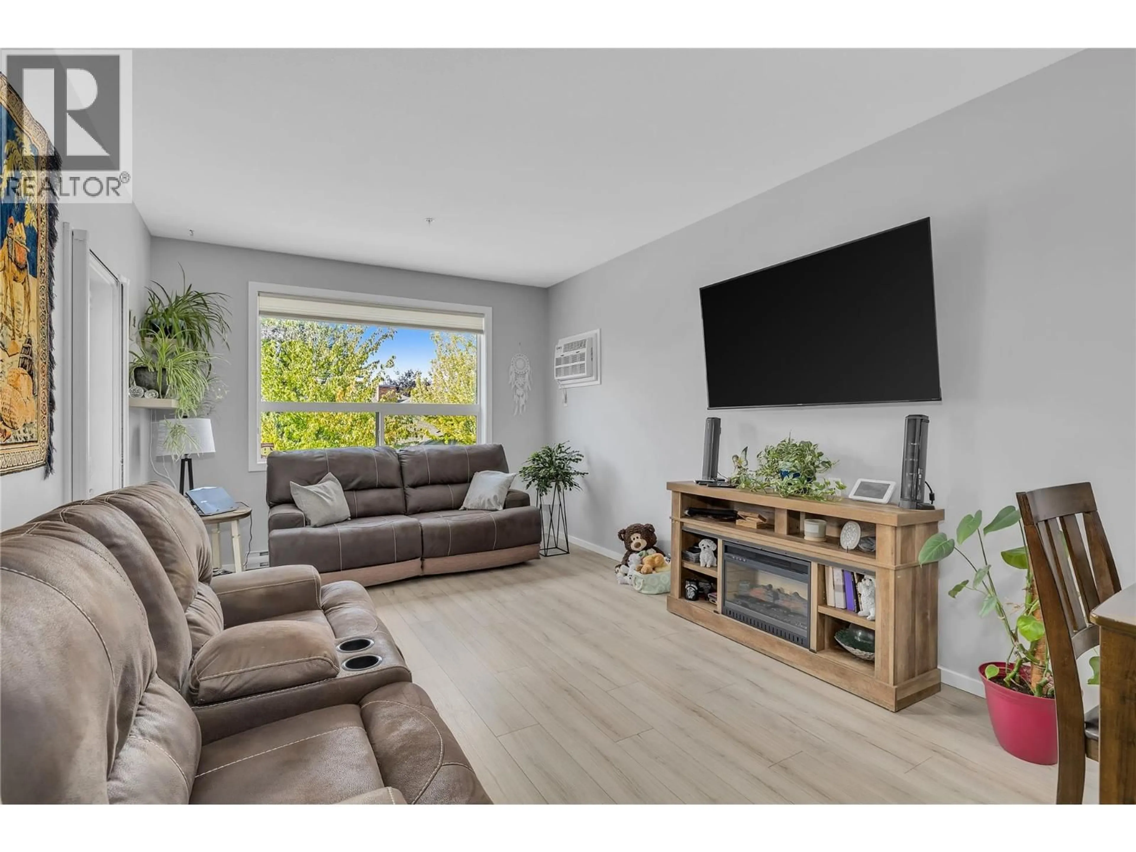 Living room with furniture, wood/laminate floor for 206 - 778 RUTLAND ROAD, Kelowna British Columbia V1X8B3
