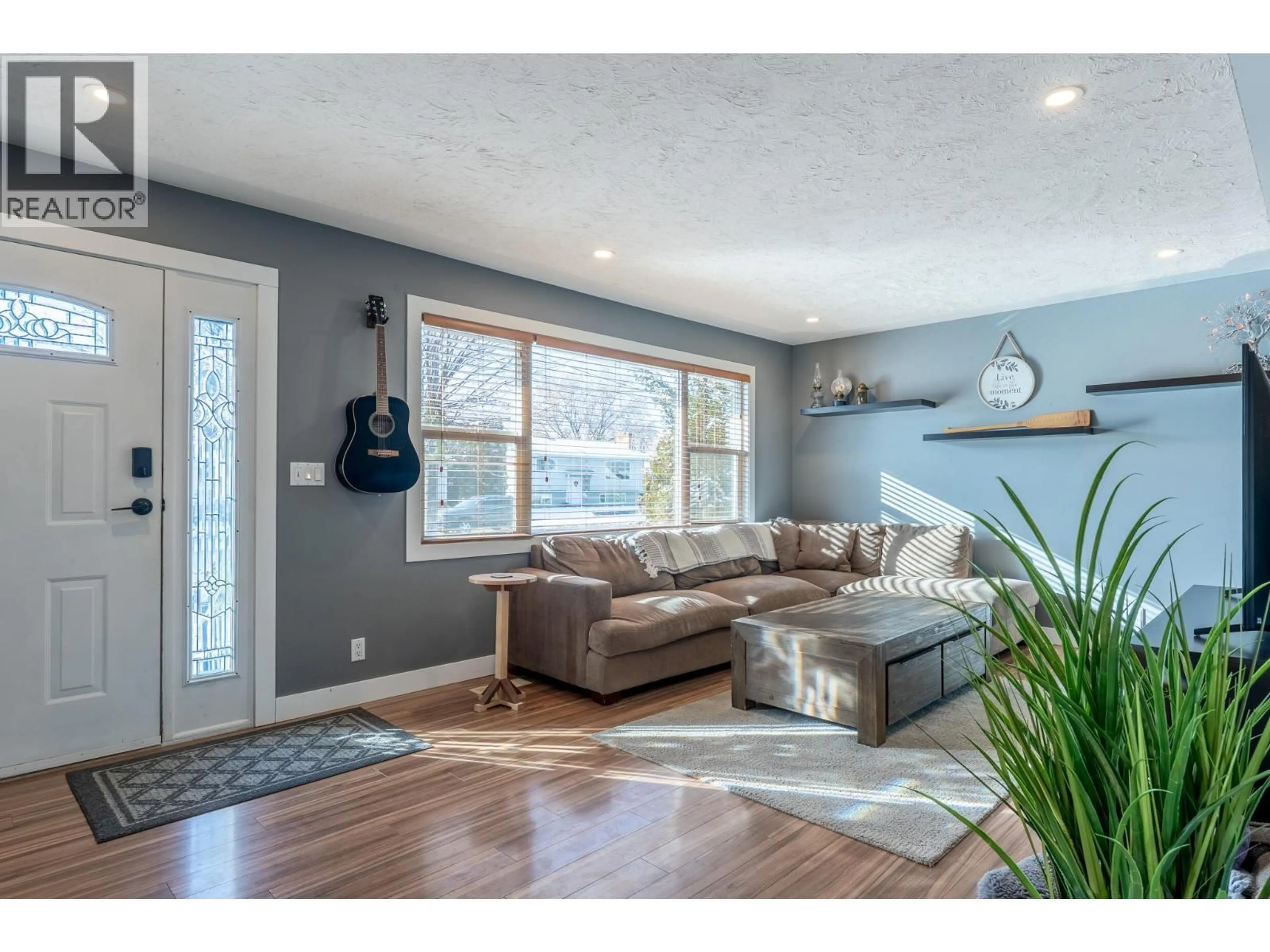 Living room with furniture, wood/laminate floor for 490 MALLACH ROAD, Kelowna British Columbia V1X2W3