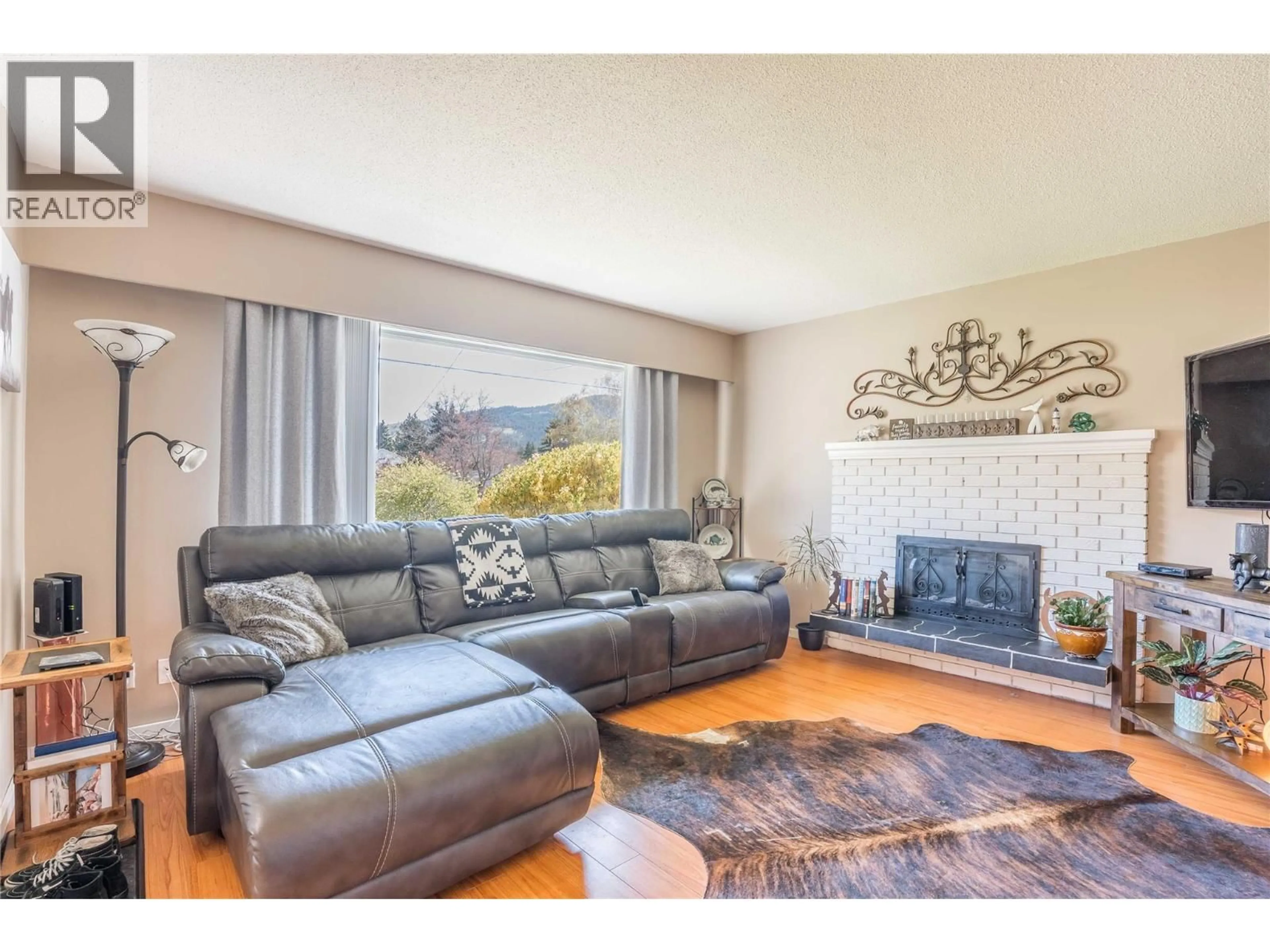 Living room with furniture, wood/laminate floor for 12240 SAUNDERS CRESCENT, Summerland British Columbia V0H1Z0