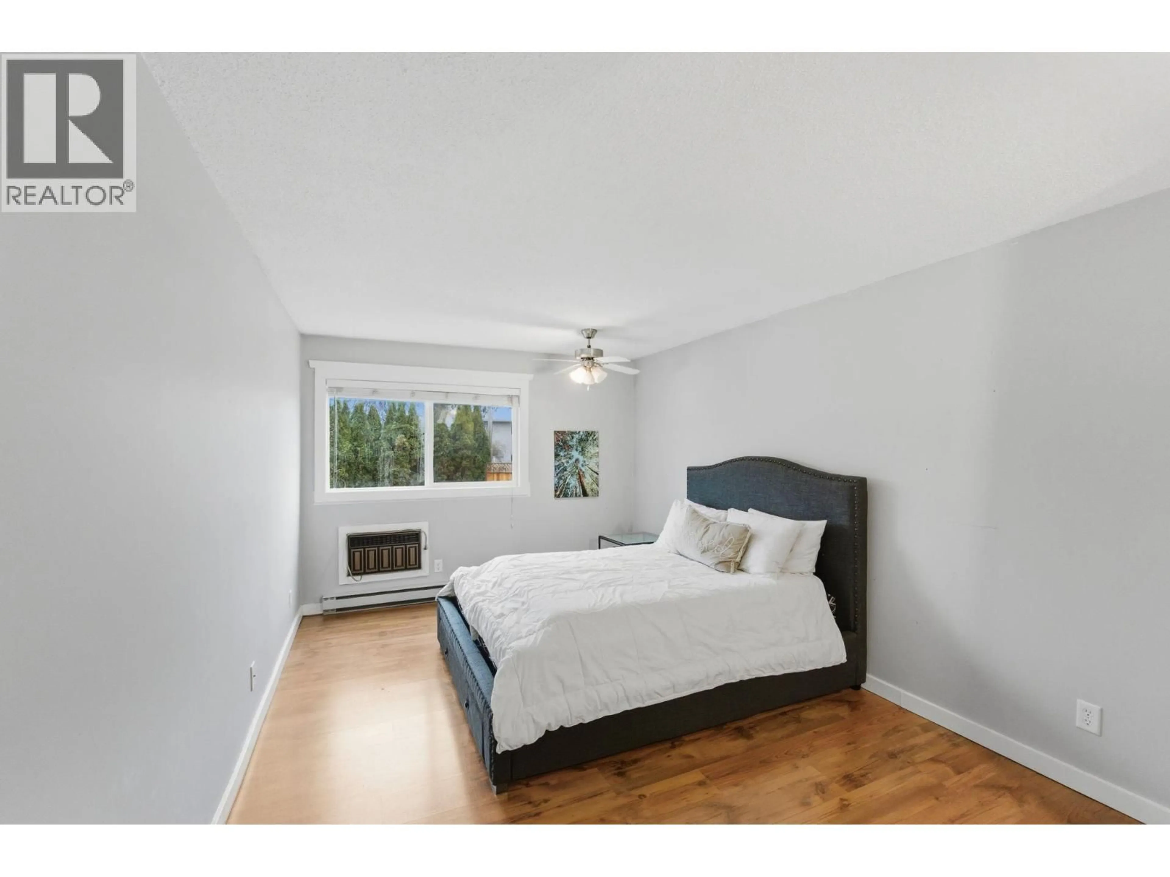 Bedroom with bed, wood/laminate floor for 207 - 445 ALL STAR COURT, Kelowna British Columbia V1X5N7