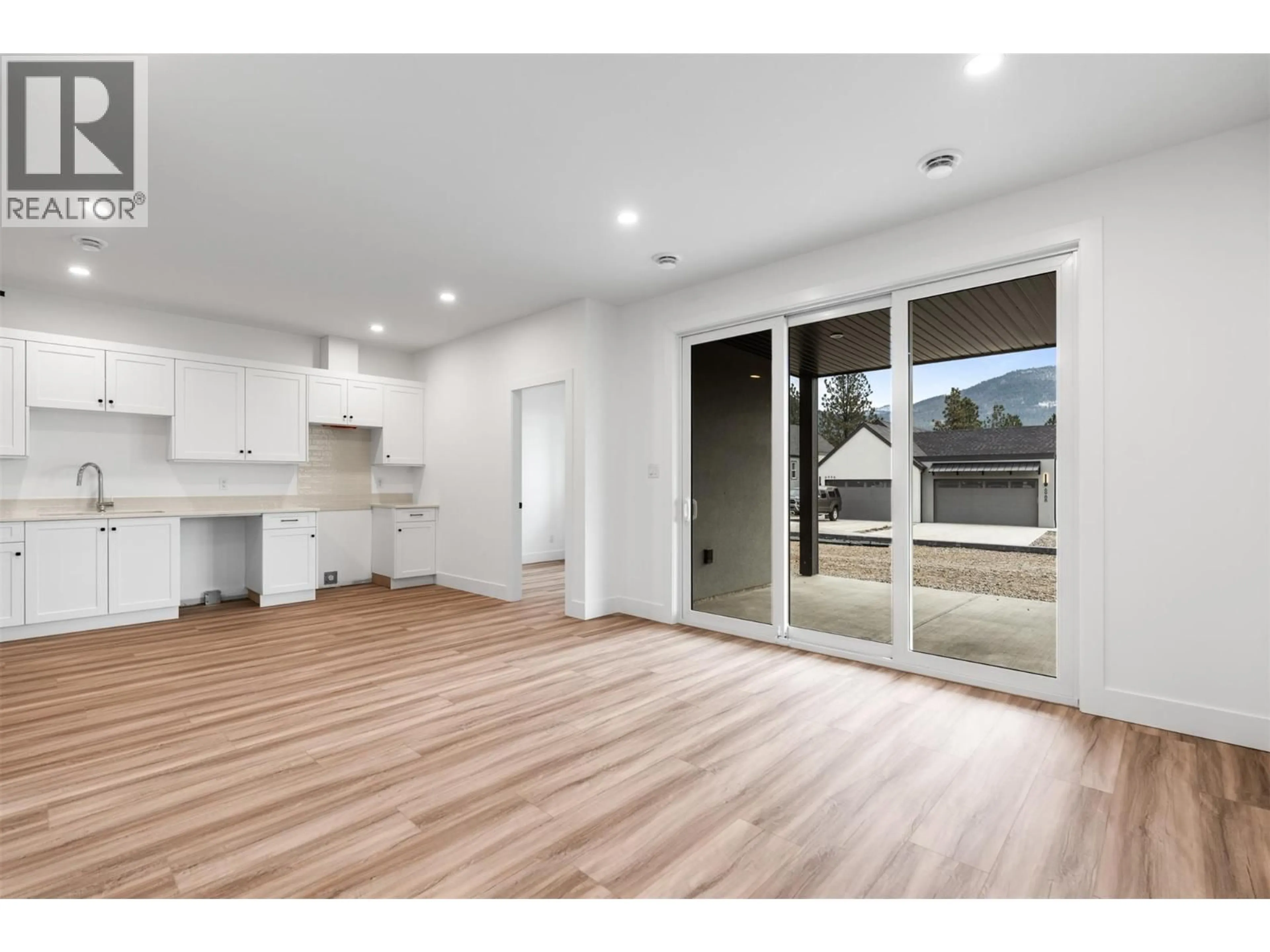 Open concept kitchen, wood/laminate floor for 7077 MANNING PLACE, Vernon British Columbia V1B0B6