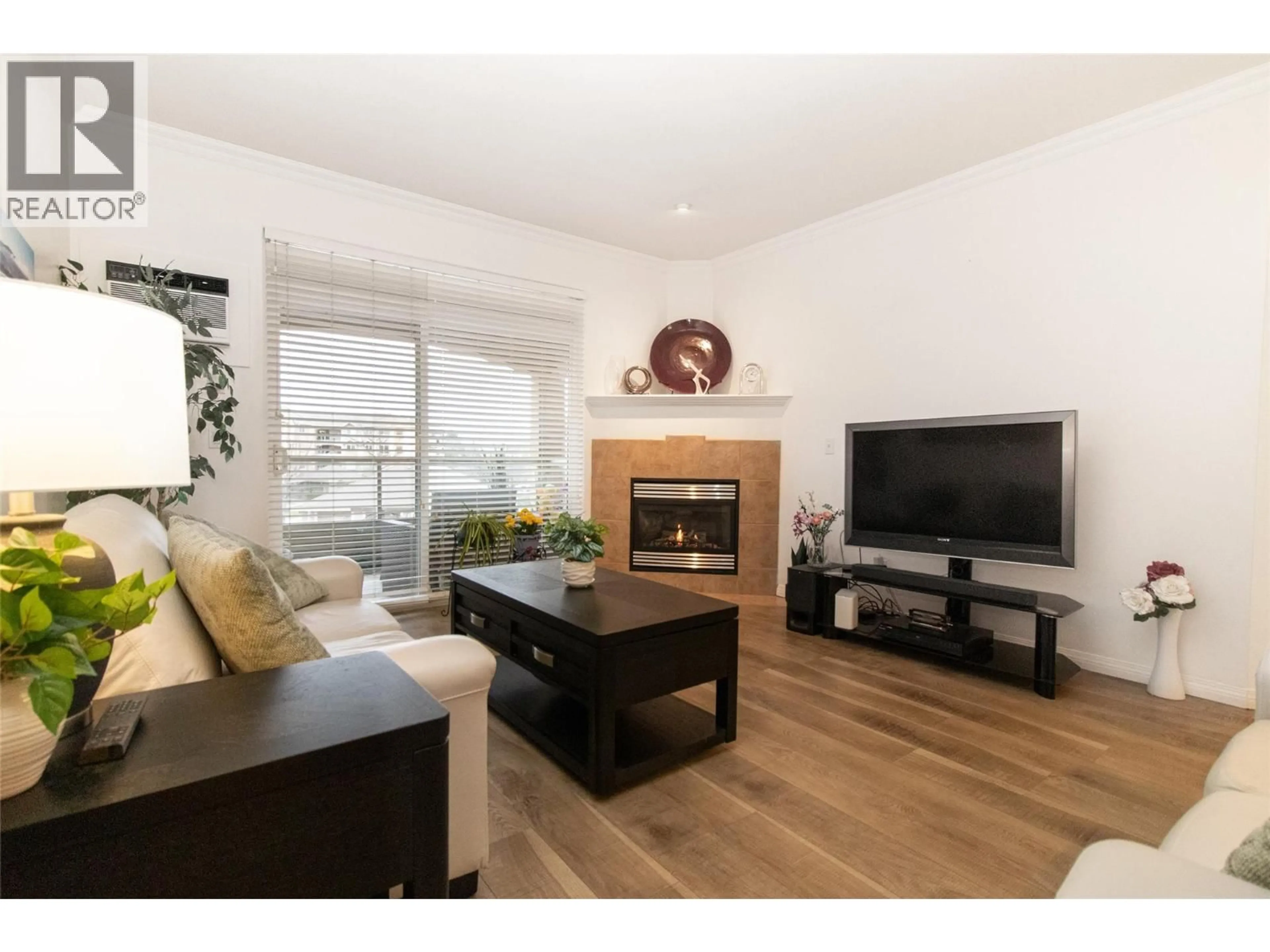 Living room with furniture, wood/laminate floor for 309 - 1960 ENTERPRISE WAY, Kelowna British Columbia V1Y9S5