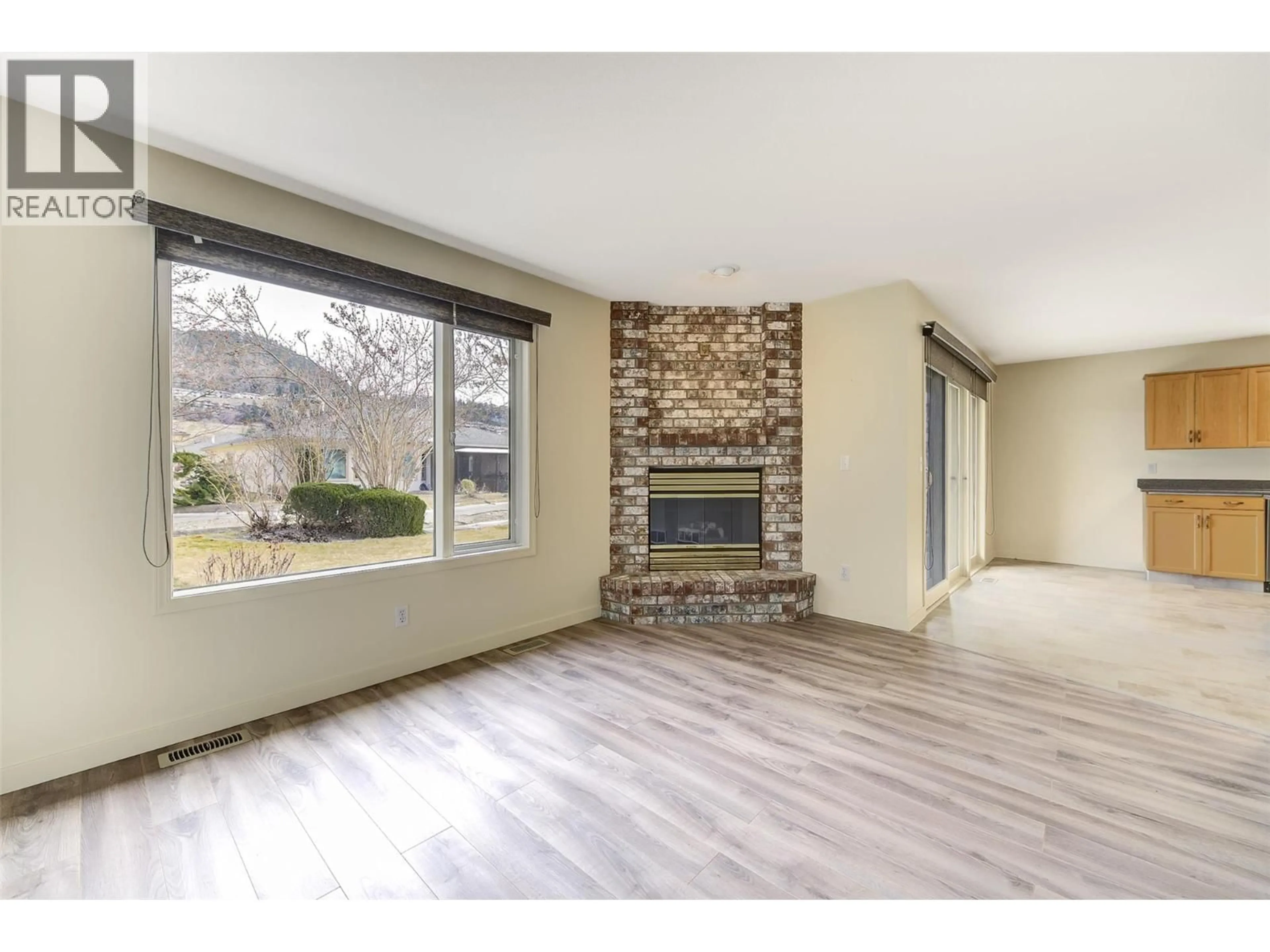 Living room with furniture, wood/laminate floor for 203 - 595 YATES ROAD, Kelowna British Columbia V1V1P8