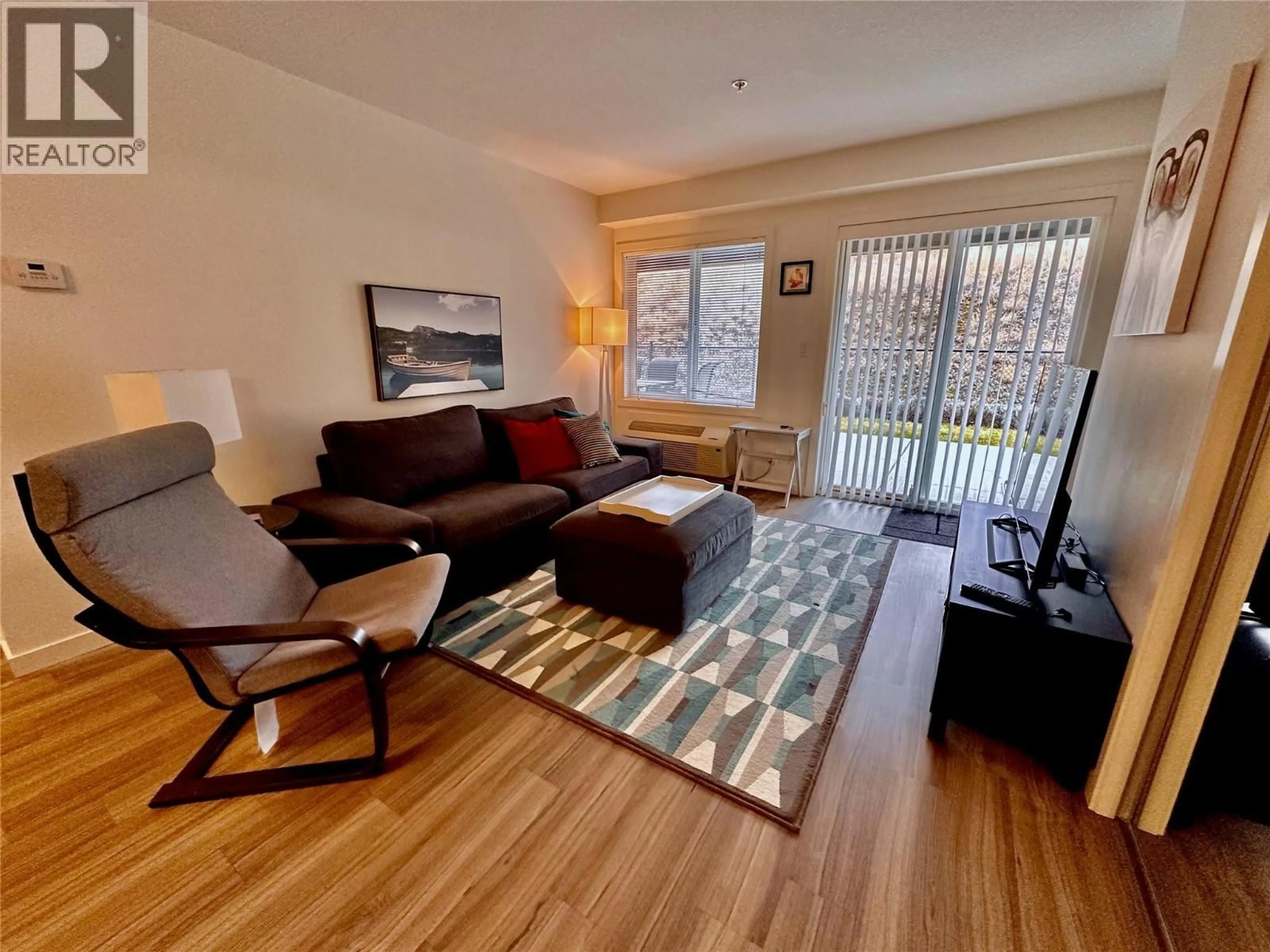 Living room with furniture, wood/laminate floor for 108 - 883 ACADEMY WAY, Kelowna British Columbia V1V0A2
