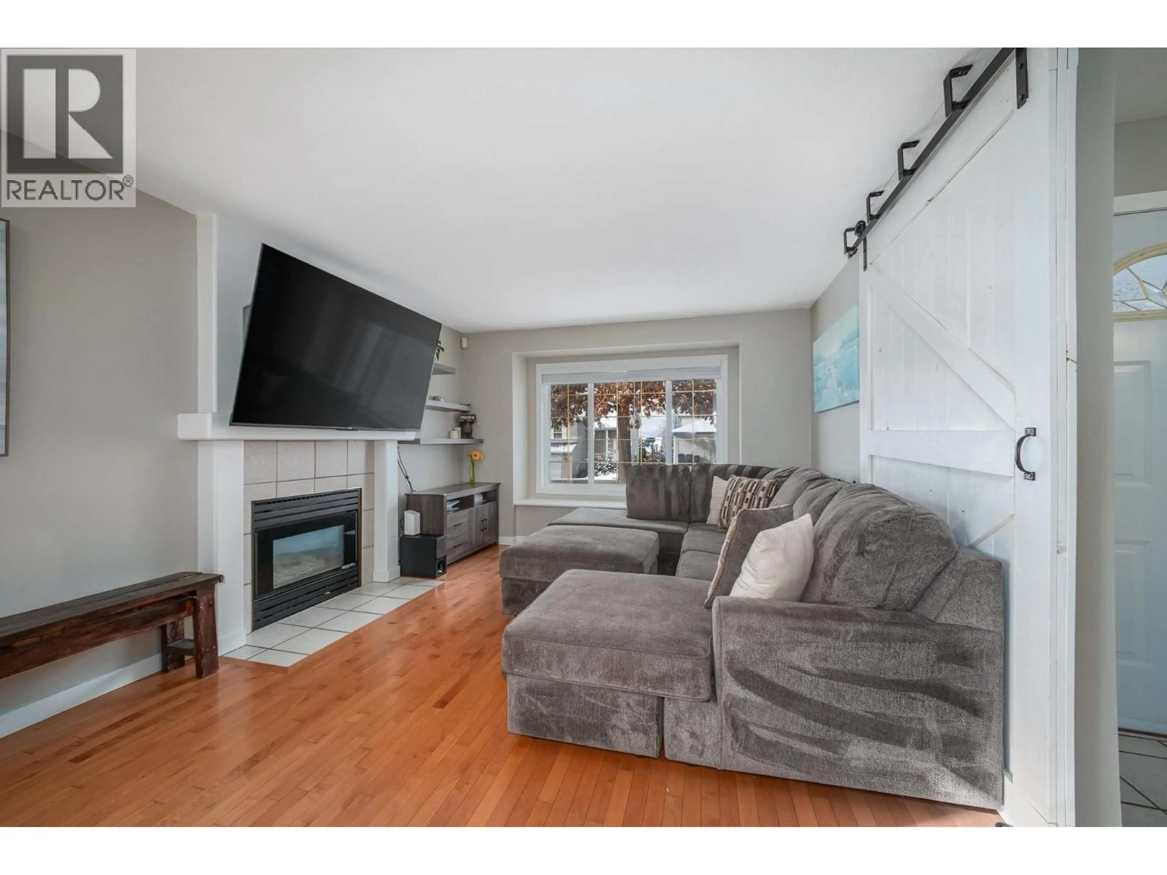 Living room with furniture, wood/laminate floor for 9 - 4450 POSTILL DRIVE, Kelowna British Columbia V1X7T9
