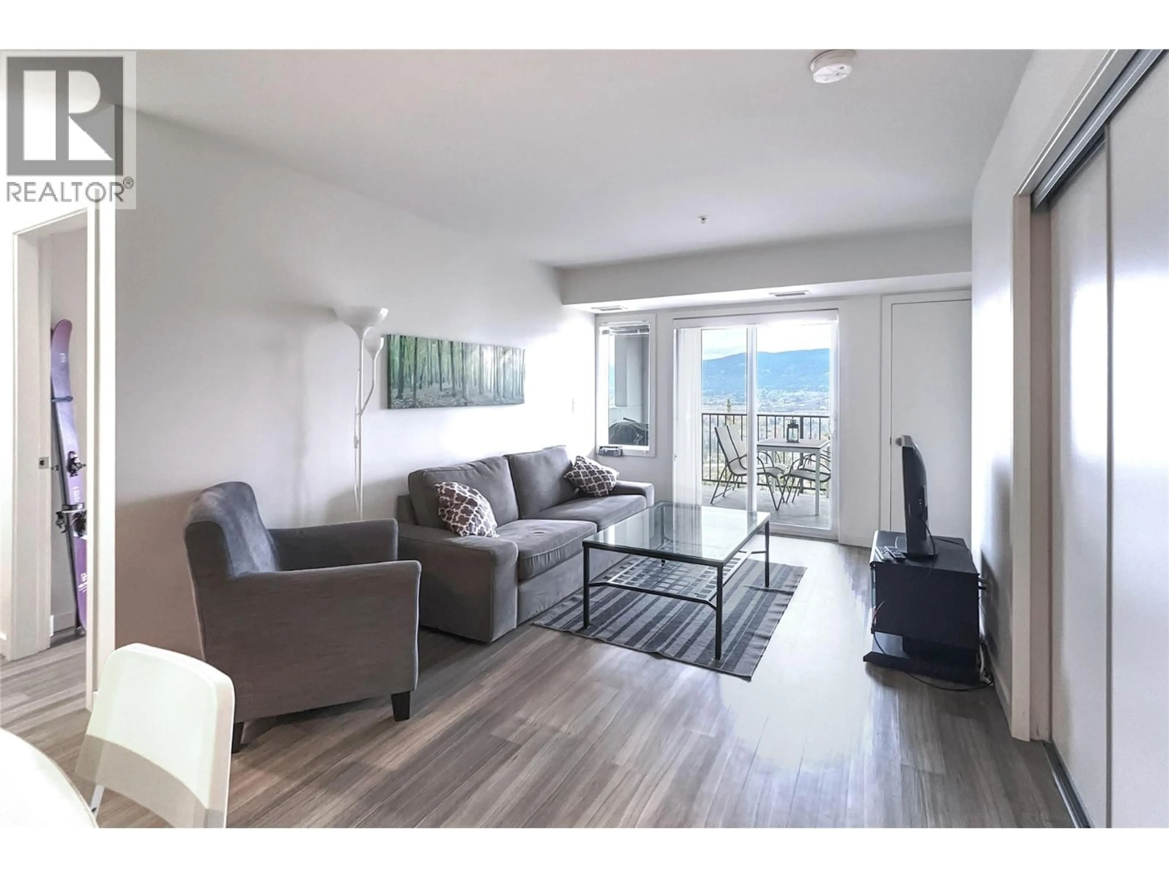 Living room with furniture, wood/laminate floor for 218 - 775 ACADEMY WAY, Kelowna British Columbia V1V0A5