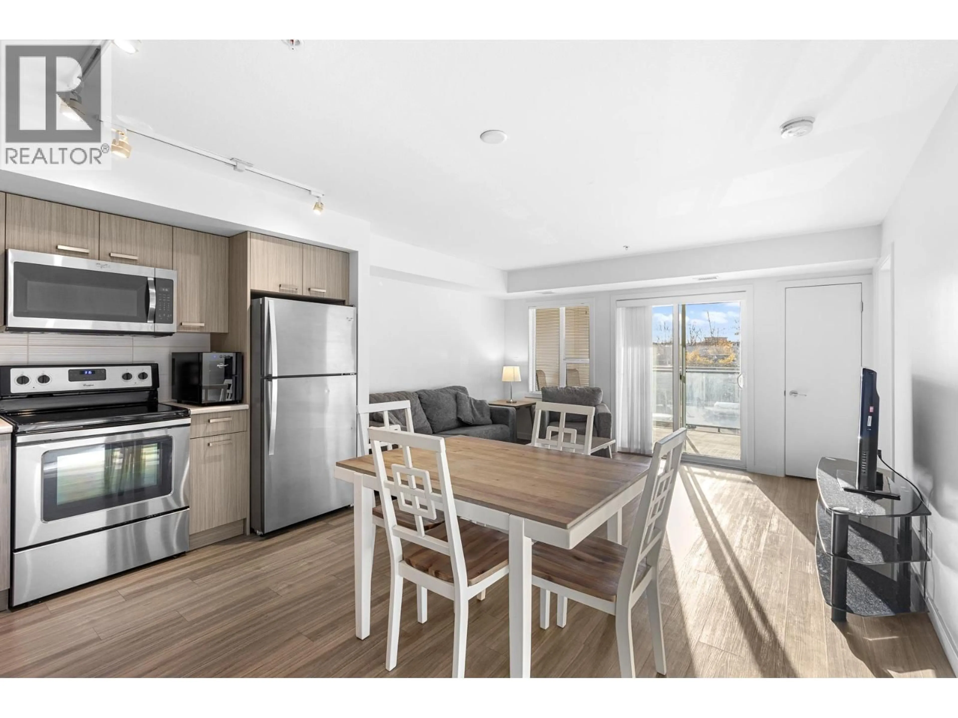 Open concept kitchen, wood/laminate floor for 106 - 775 ACADEMY WAY, Kelowna British Columbia V1V0A5