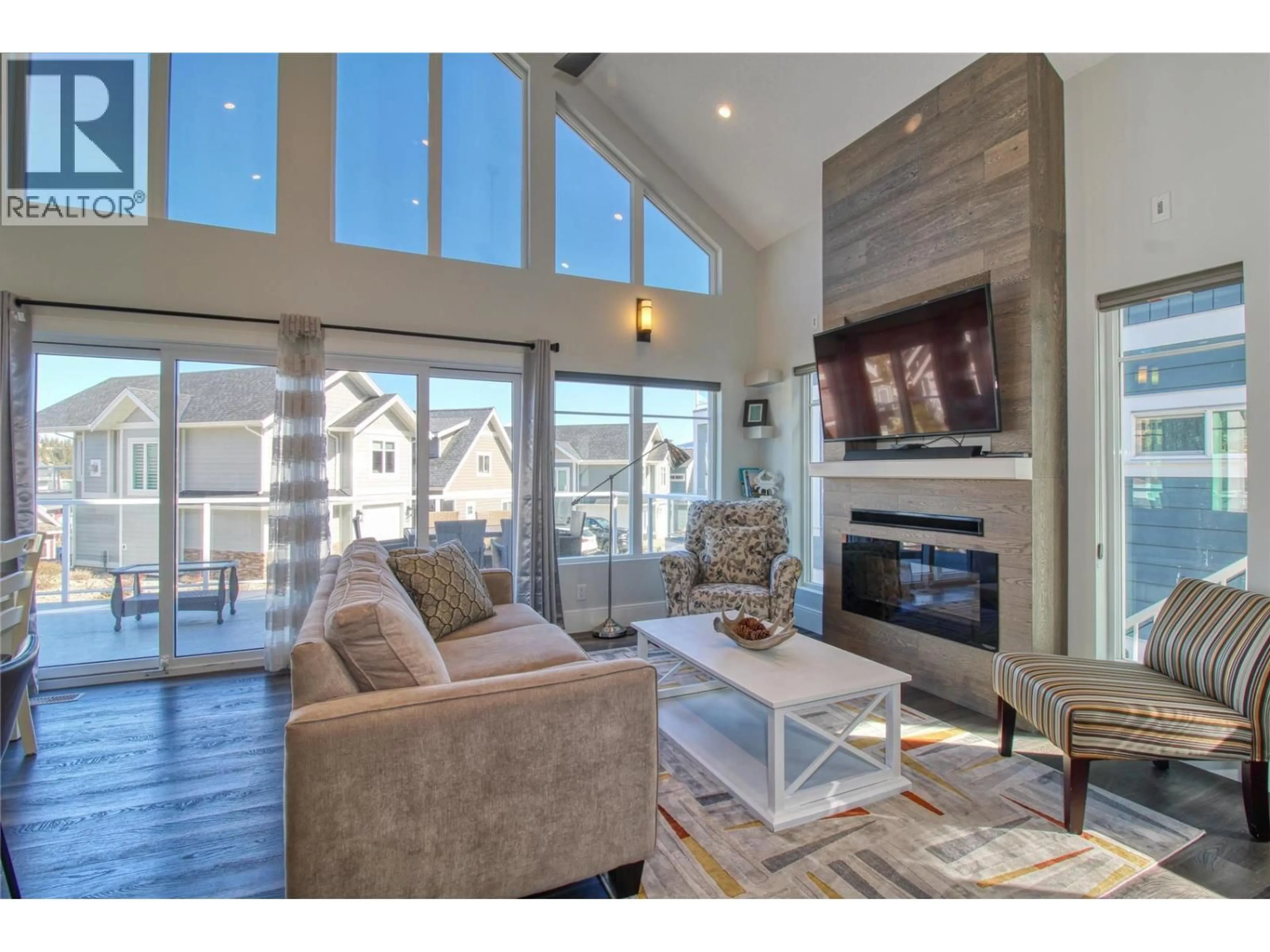 Living room with furniture, wood/laminate floor for 302 - 6742 MARBELLA LOOP, Kelowna British Columbia V1Z3R8