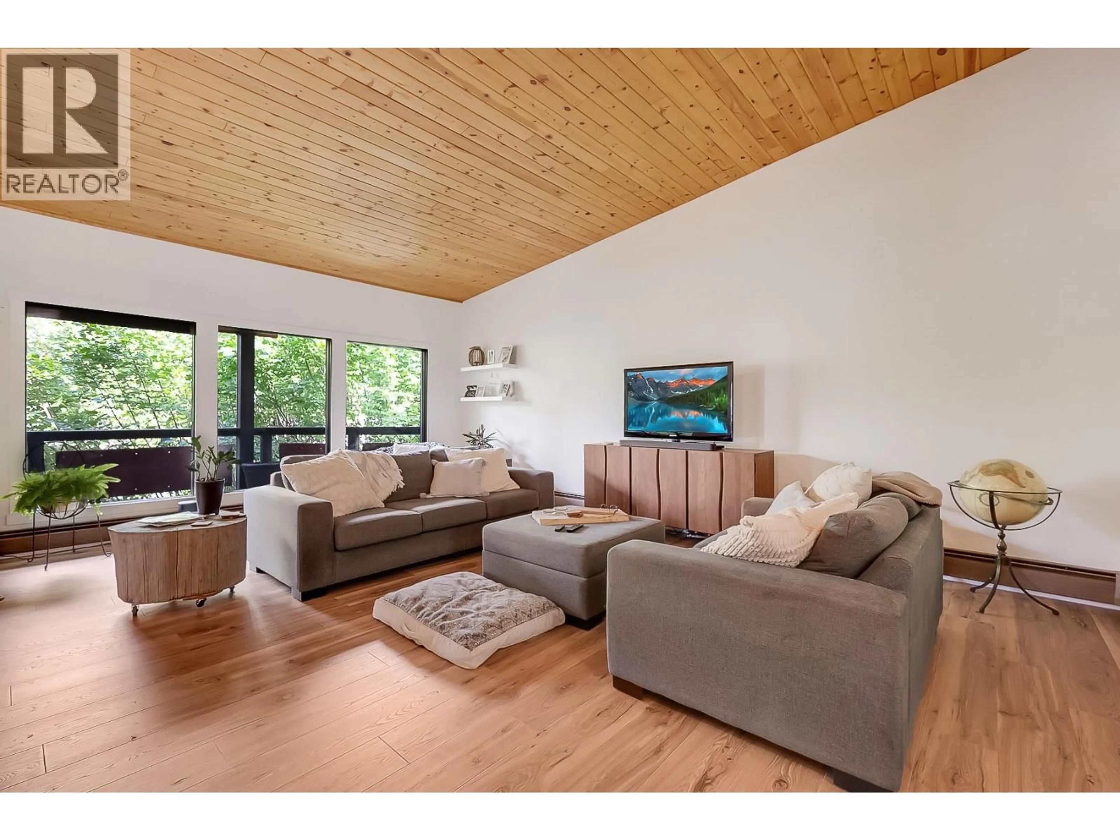 Living room with furniture, wood/laminate floor for 1590 WILLOW CRESCENT, Kelowna British Columbia V1Y4K3