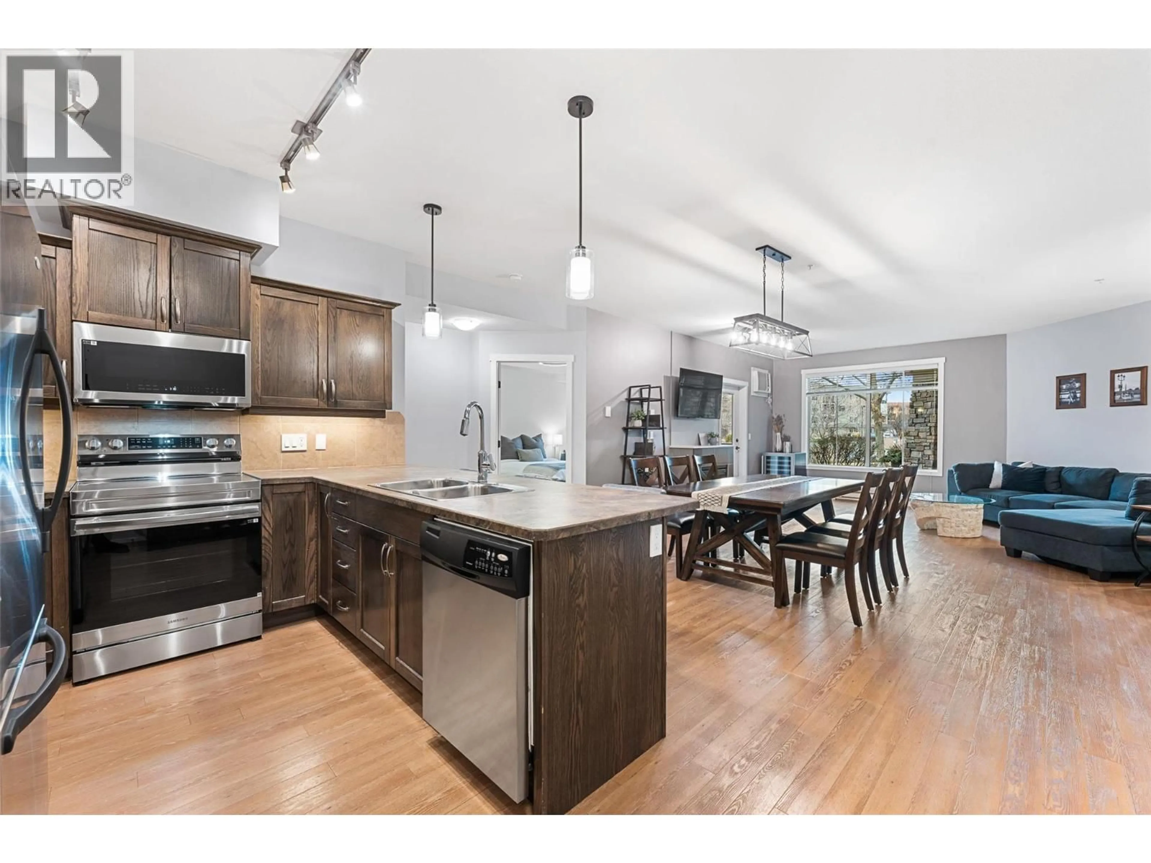 Open concept kitchen, wood/laminate floor for 101 - 3739 CASORSO ROAD, Kelowna British Columbia V1W5E8