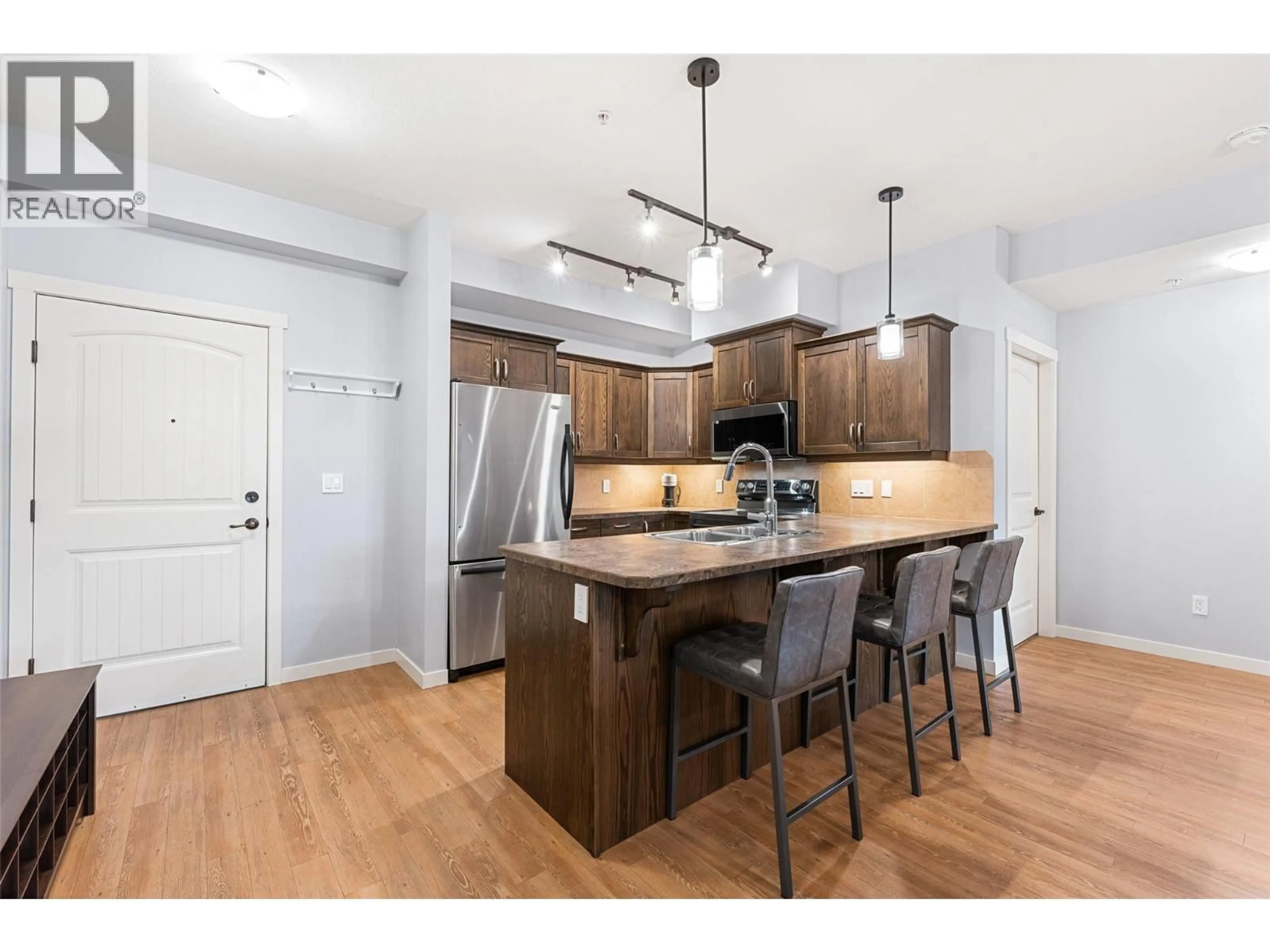 Open concept kitchen, wood/laminate floor for 101 - 3739 CASORSO ROAD, Kelowna British Columbia V1W5E8